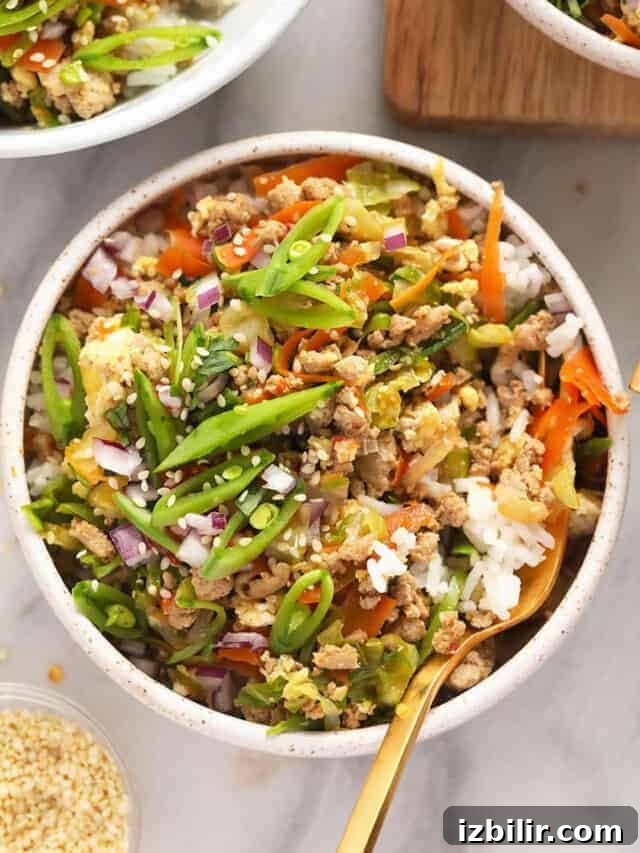 A bowl of asian stir fry with rice and vegetables.