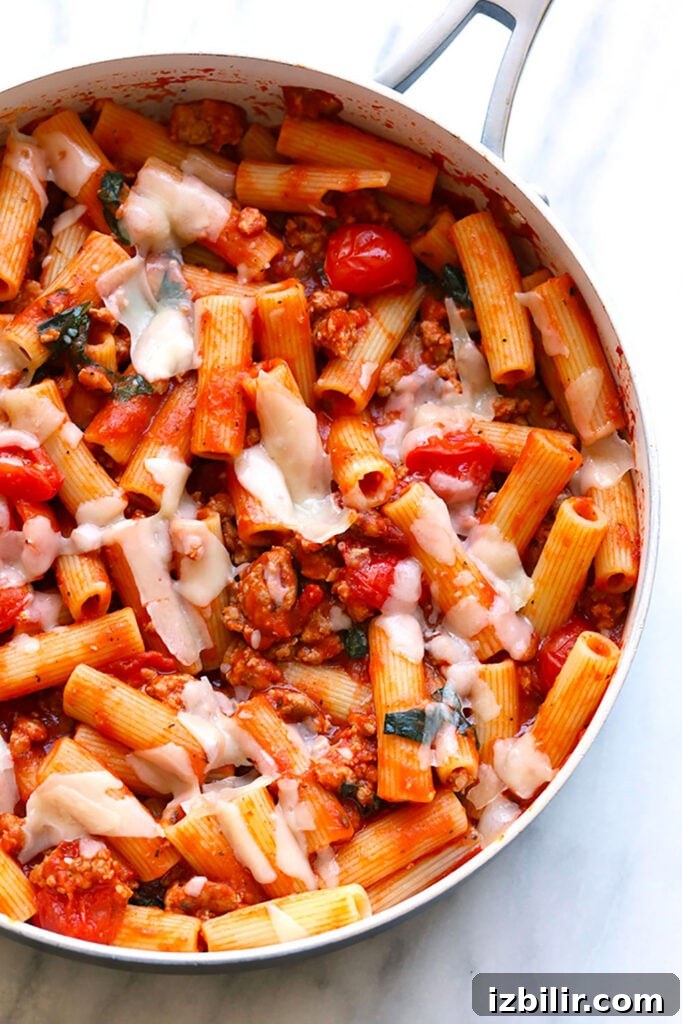 A skillet filled with pasta and sausage.