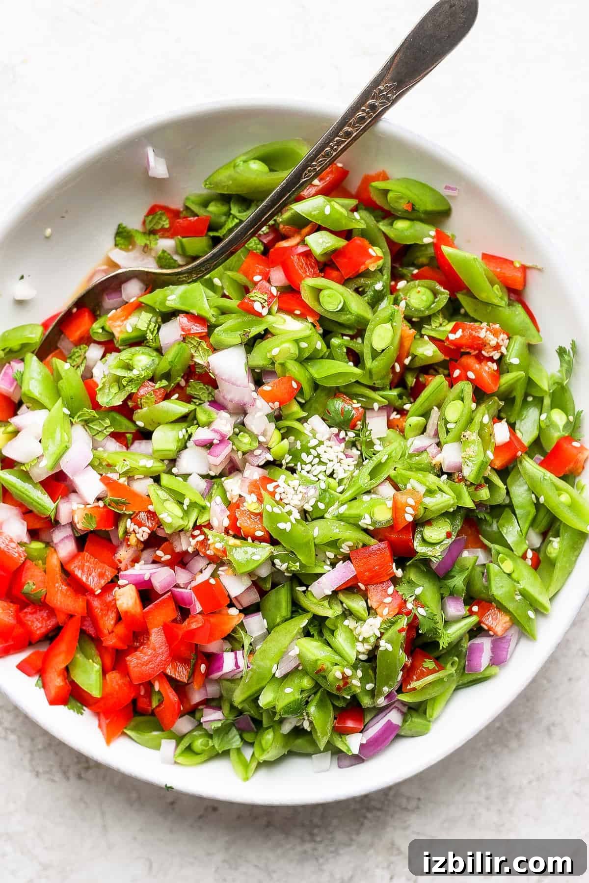 Ginger Pea Salad in a bowl topped with sesame seeds.