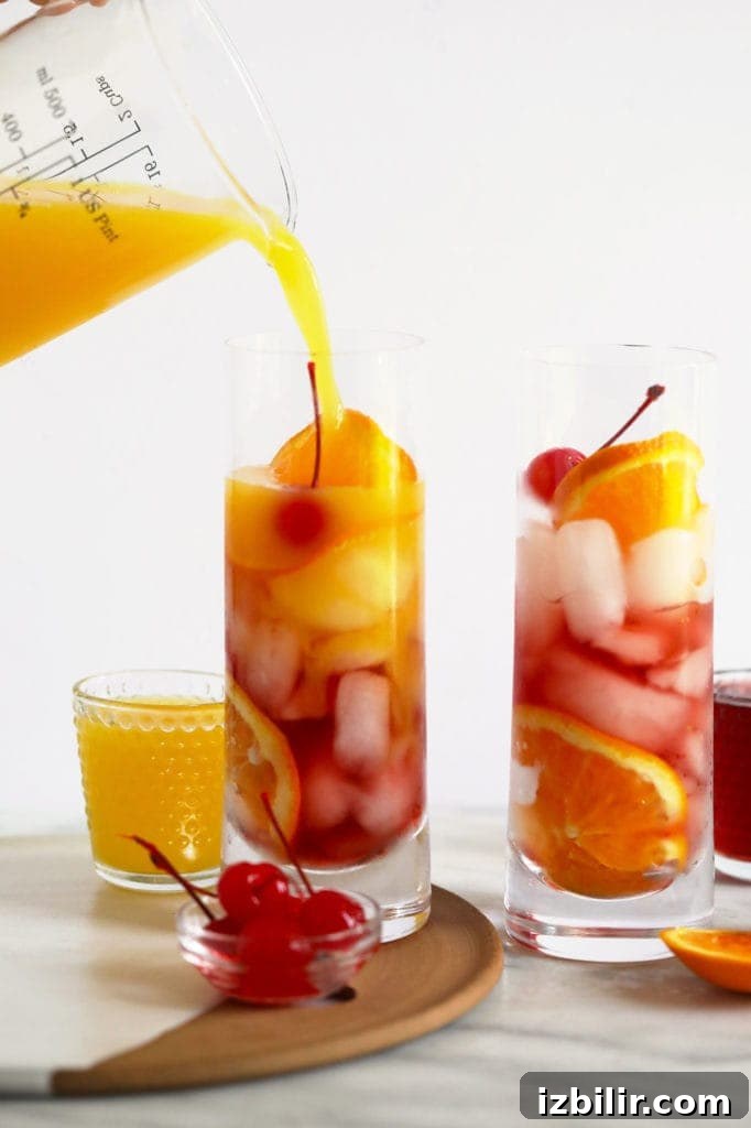 Pouring orange juice into a sex on the beach cocktail.