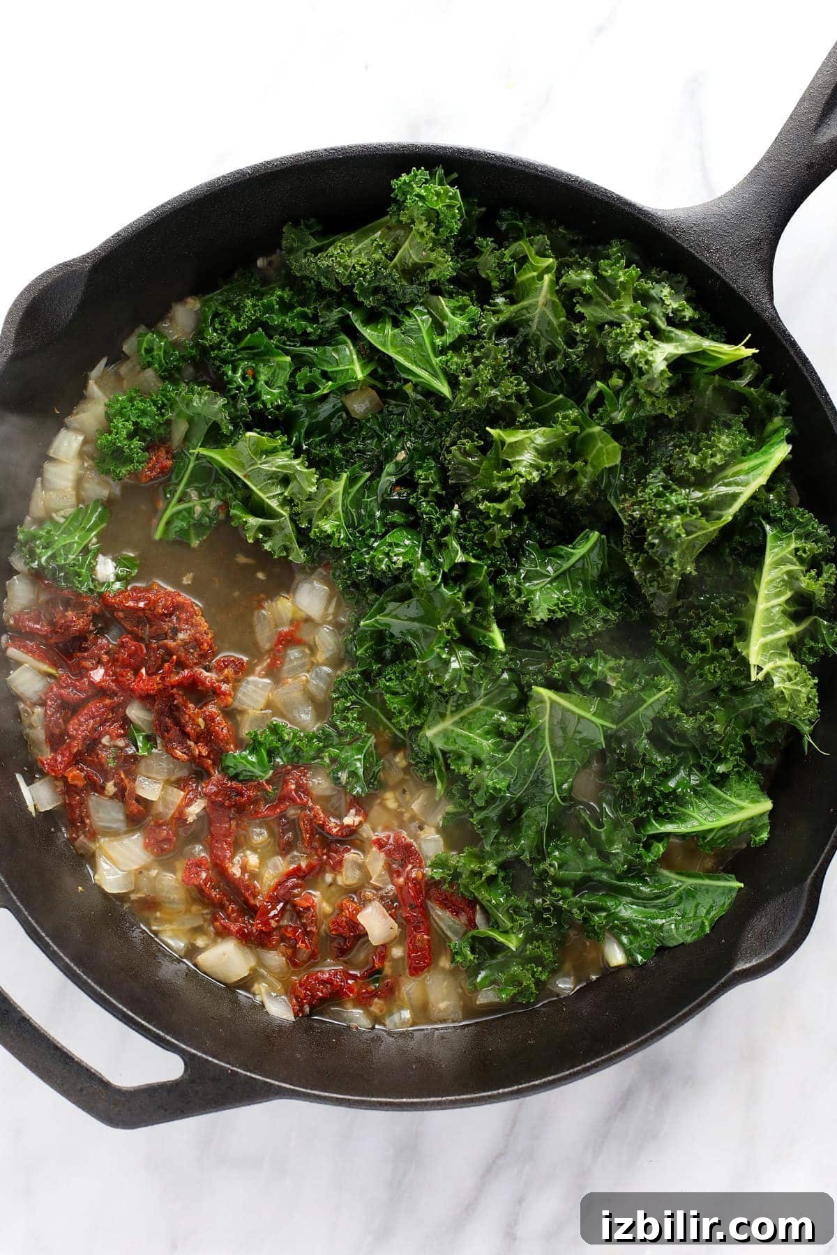 sauteed veggies in a cast iron skillet for creamy tuscan chicken and gnocchi