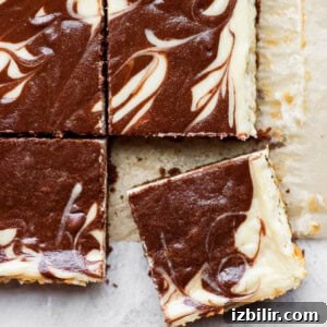 a slice of chocolate swirl cheesecake bars on top of a piece of paper.