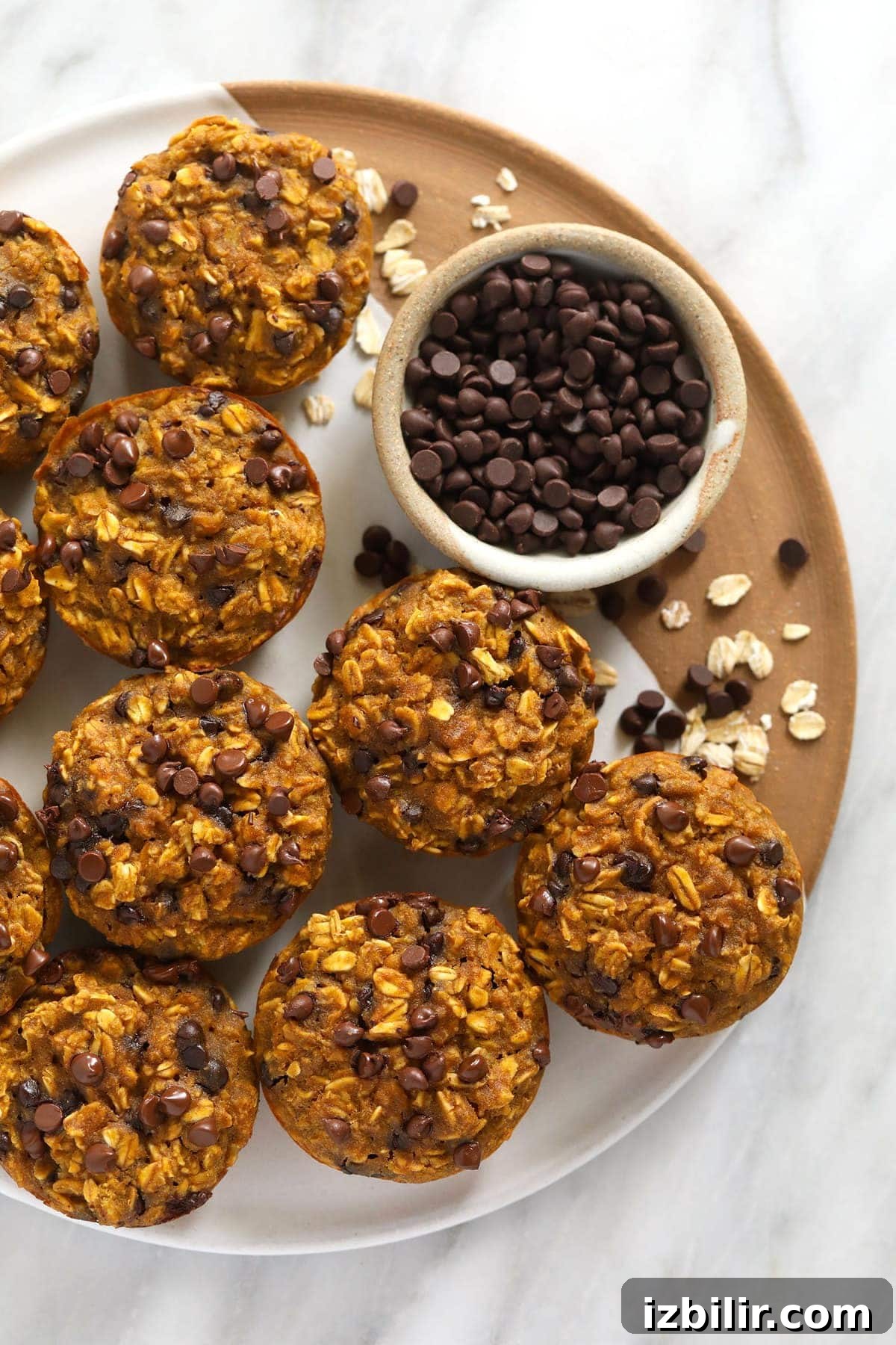 Make Ahead Pumpkin Oatmeal Cups Recipe 2 Pumpkin oatmeal cups on a tray with mini chocolate chips.