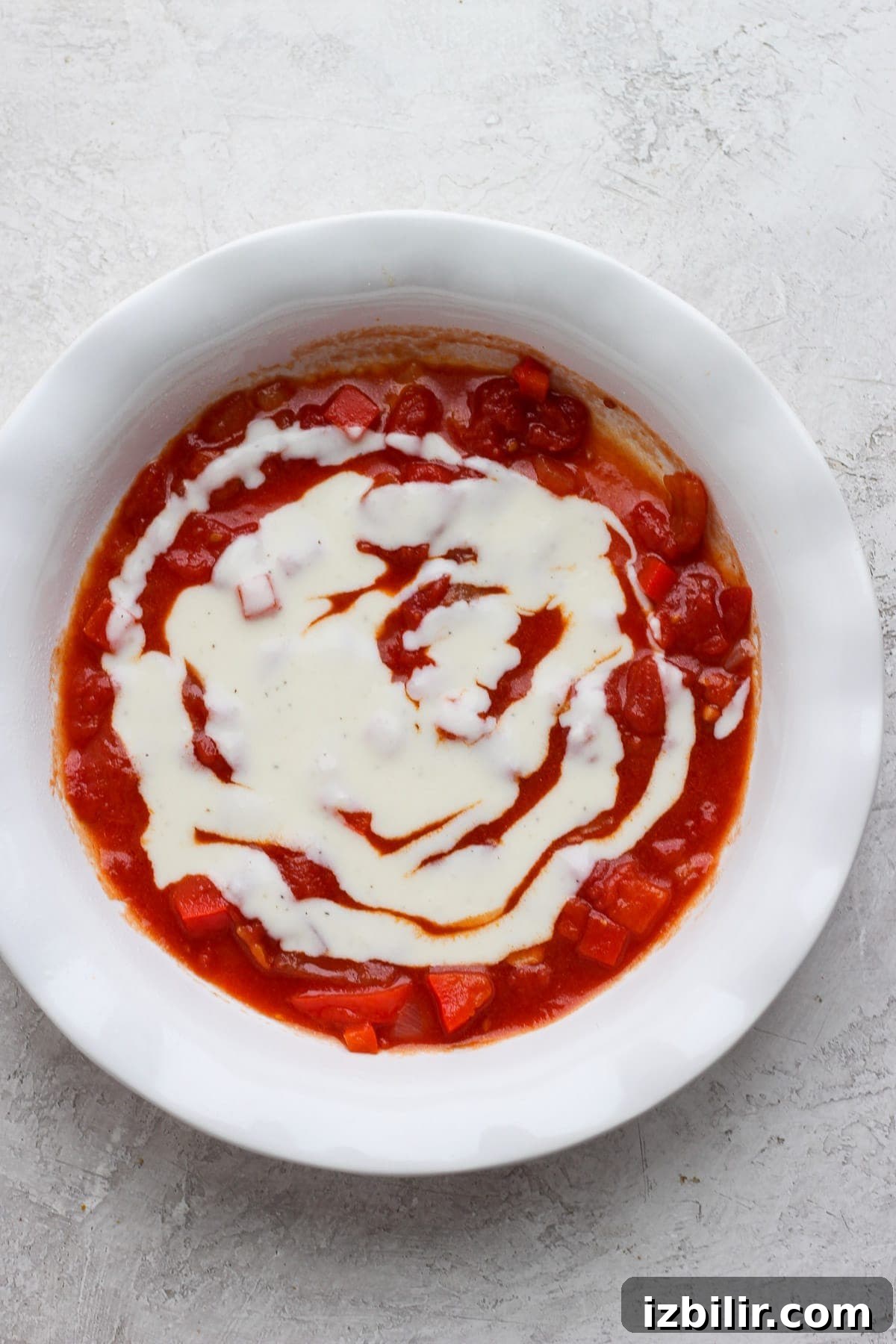 Authentic French Ratatouille Recipe 5 Red and white sauce in the bottom of a baking dish.