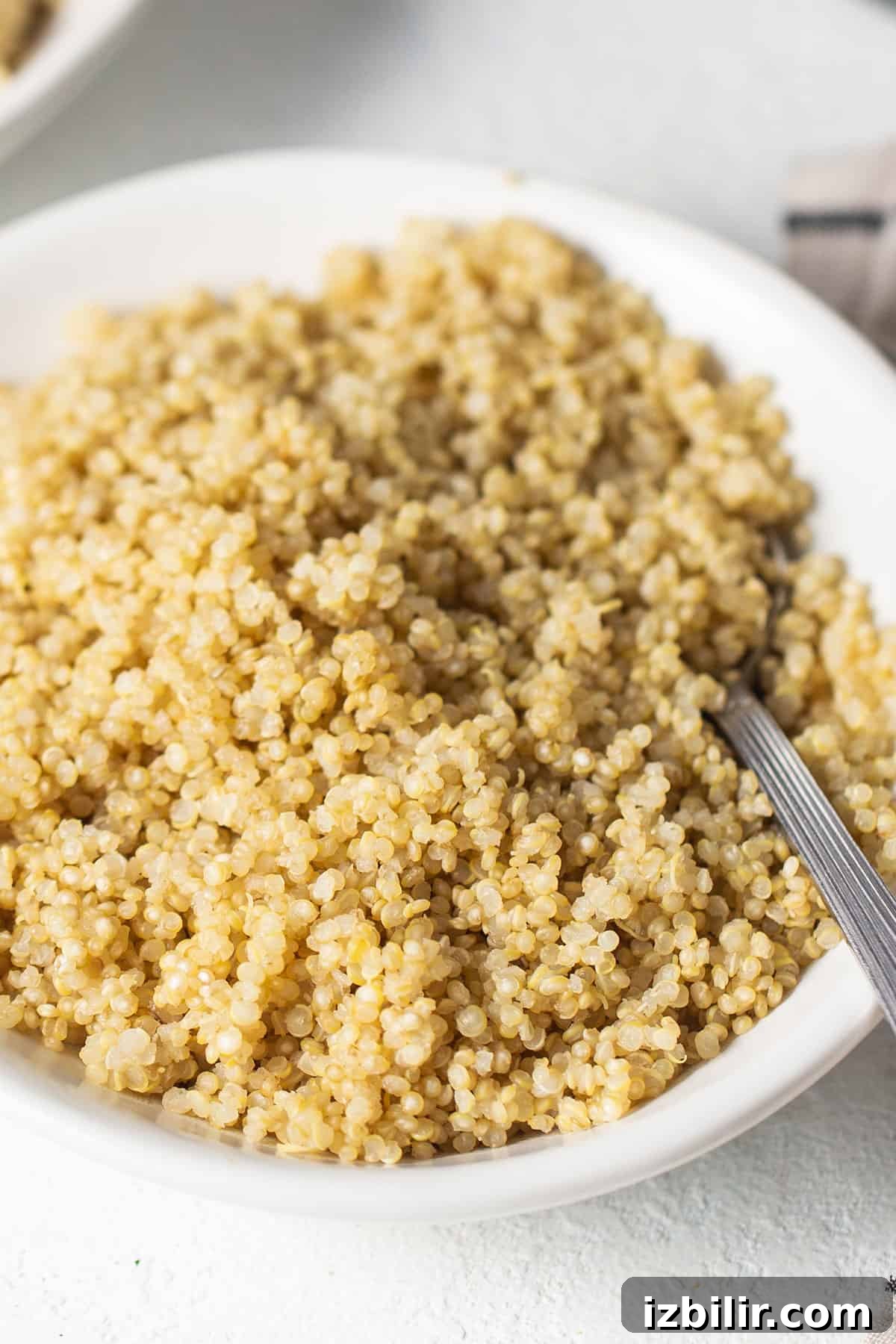 A white bowl filled with quinoa, cooked using the microwave method.