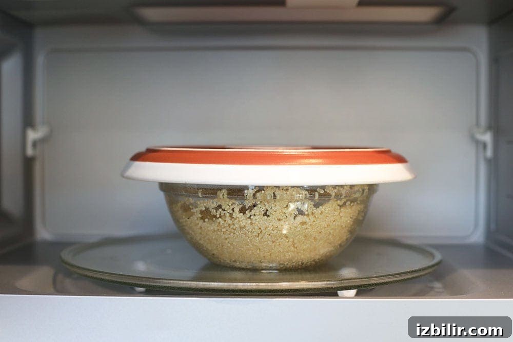 quinoa in a microwave safe bowl with a lid placed in the microwave