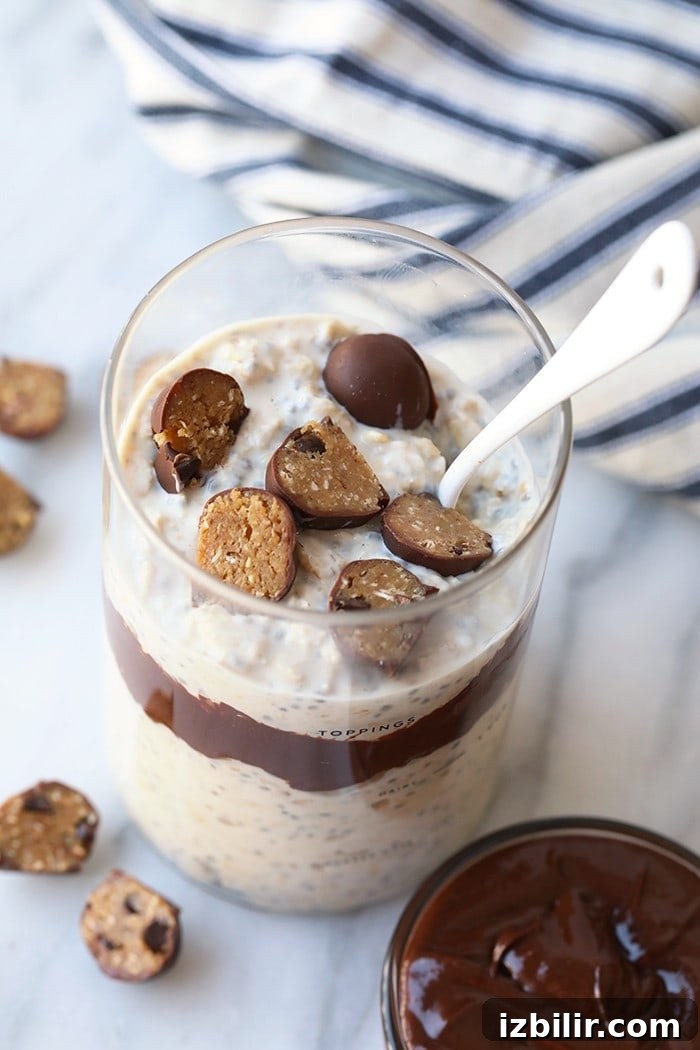 Overnight oats topped with cookie dough chunks and fudge swirl cookie dough chunks in oatmeal