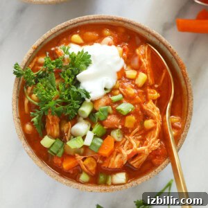 a bowl of buffalo chicken chili with sour cream and carrots.