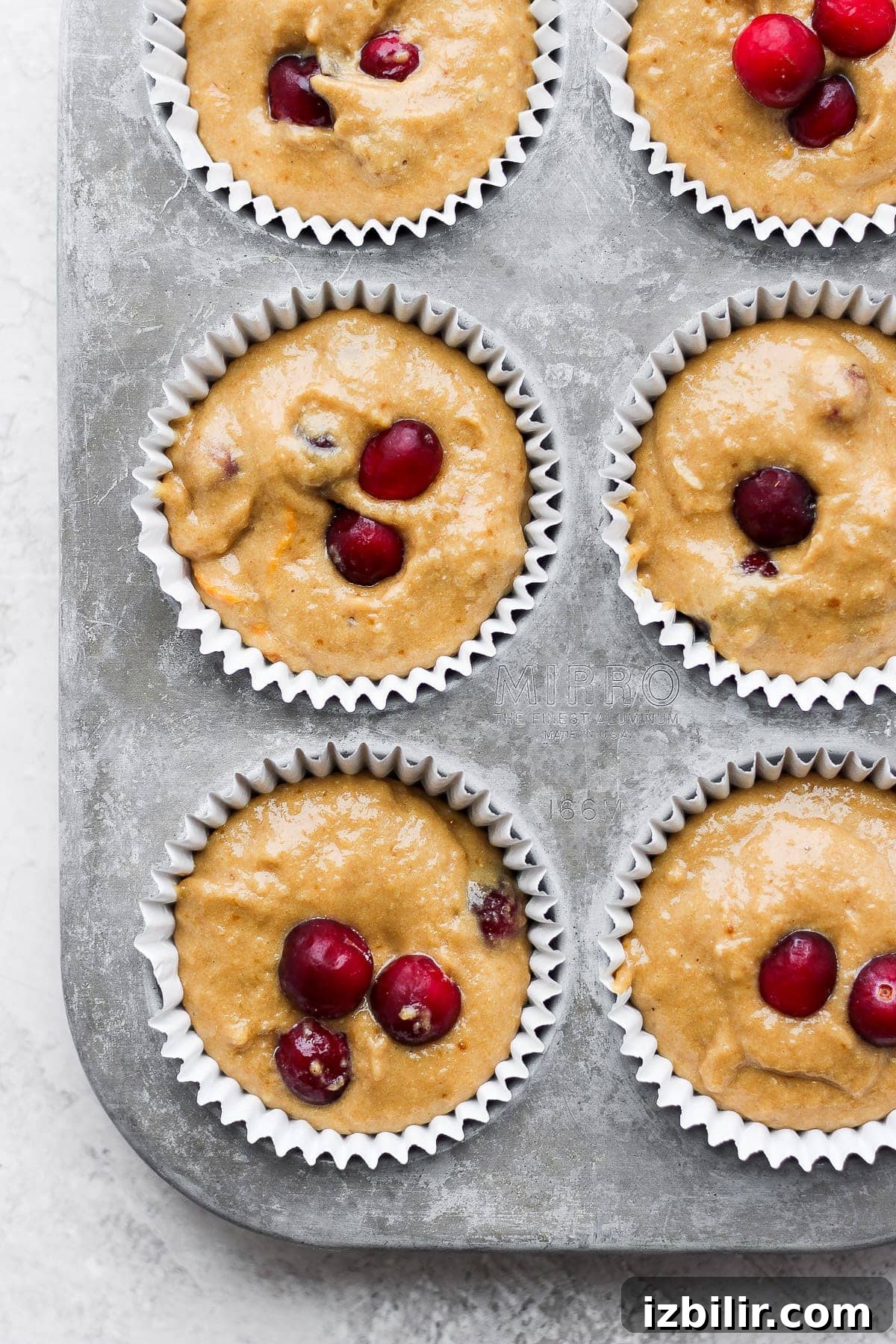 cranberry orange muffins in a muffin tin, ready to be baked
