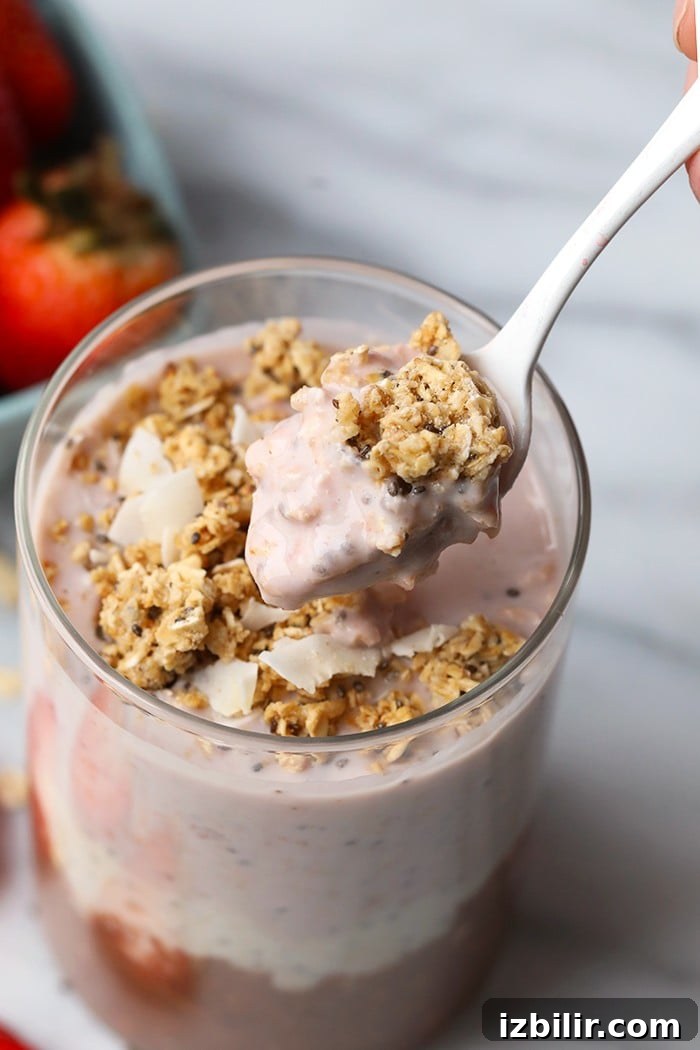 Neapolitan Overnight Oats: Chocolate, Vanilla & Strawberry 5 Neapolitan overnight oats served in a glass jar with a spoonful ready to eat.