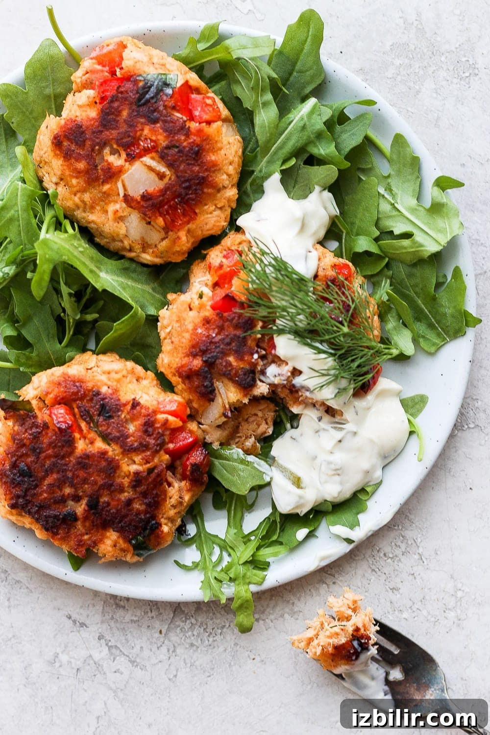 Finished salmon patties served on arugula salmon patties on a plate atop arugula