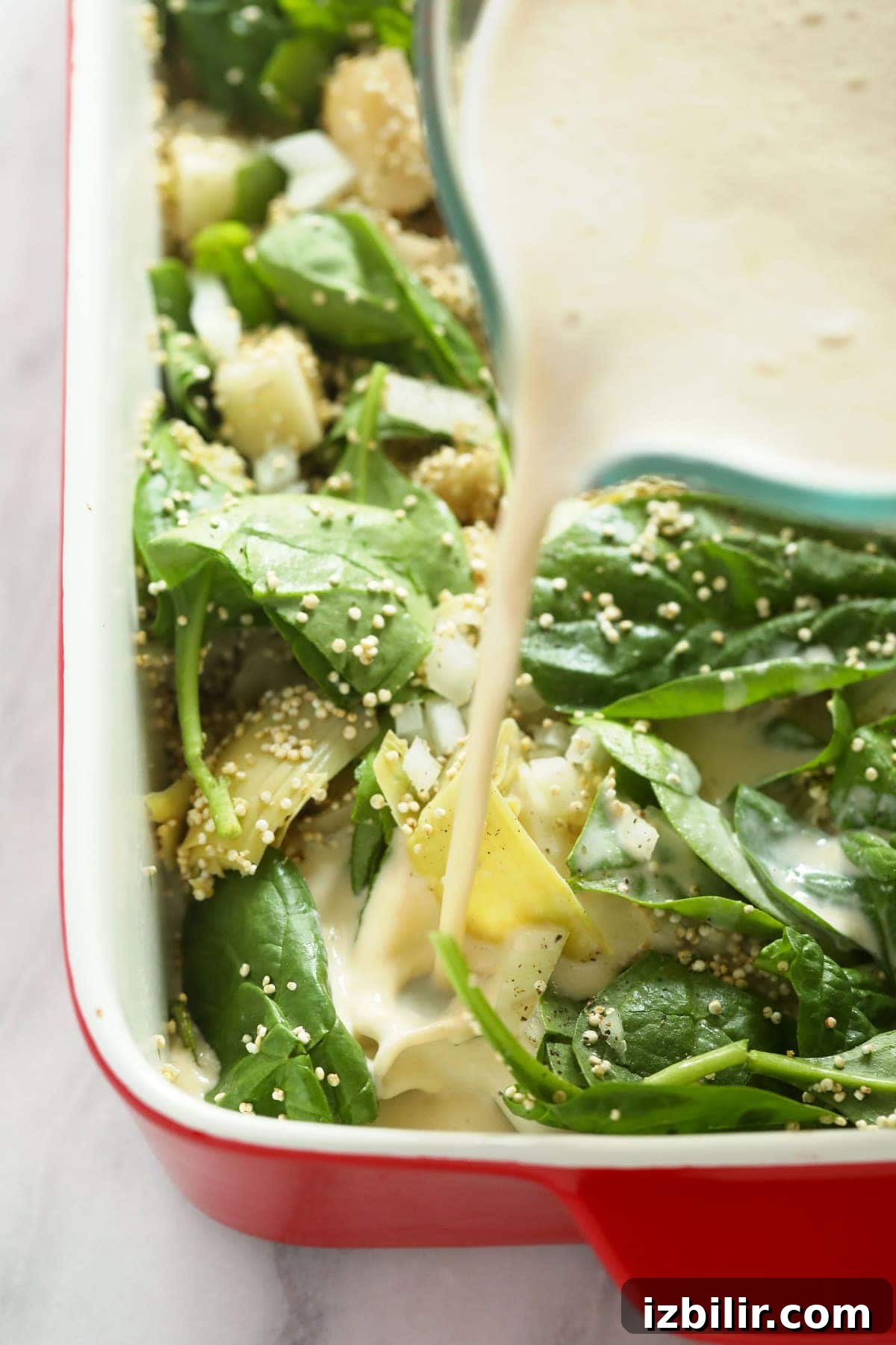 Pouring the sauce into this quinoa casserole.