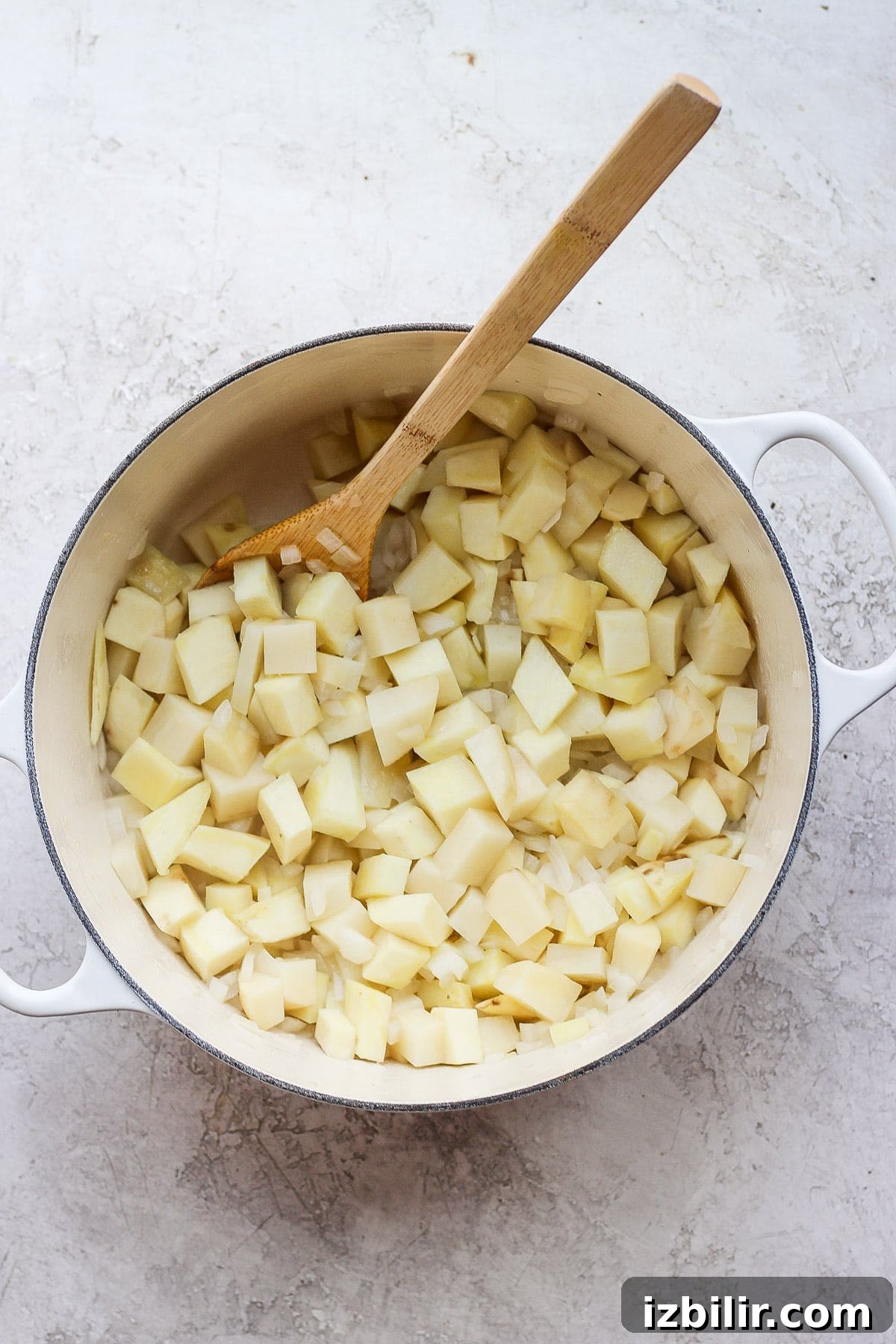 Potatoes, onions, and garlic cooking in a Dutch oven.