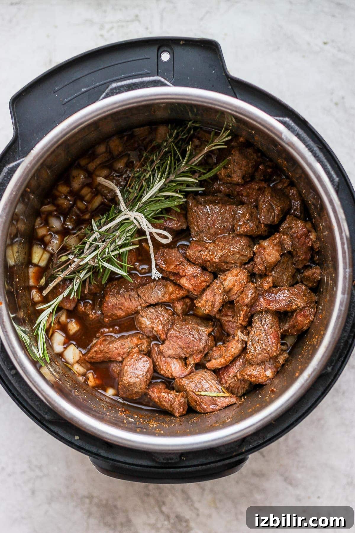 Herb bundle in the stew Beef stew in the Instant Pot with an herb bundle placed on top