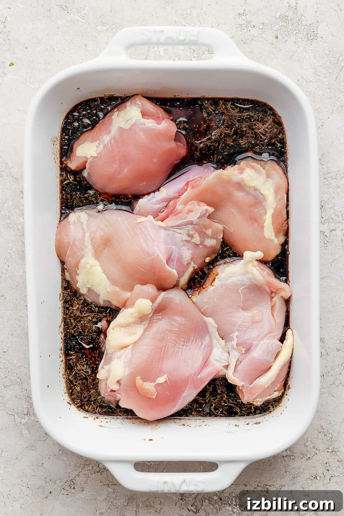 Chicken breasts in a white baking dish.