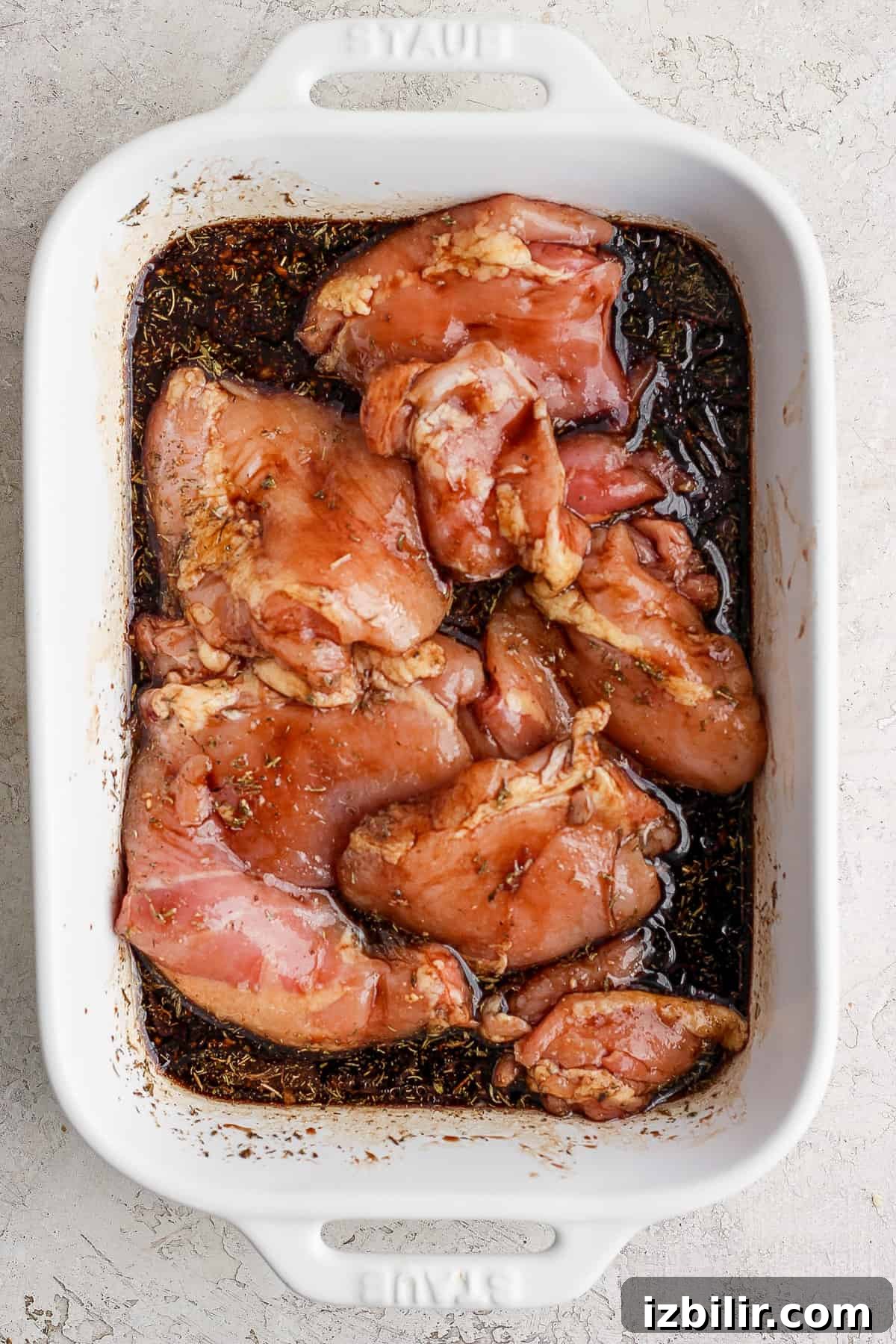 Chicken breasts in a white baking dish.