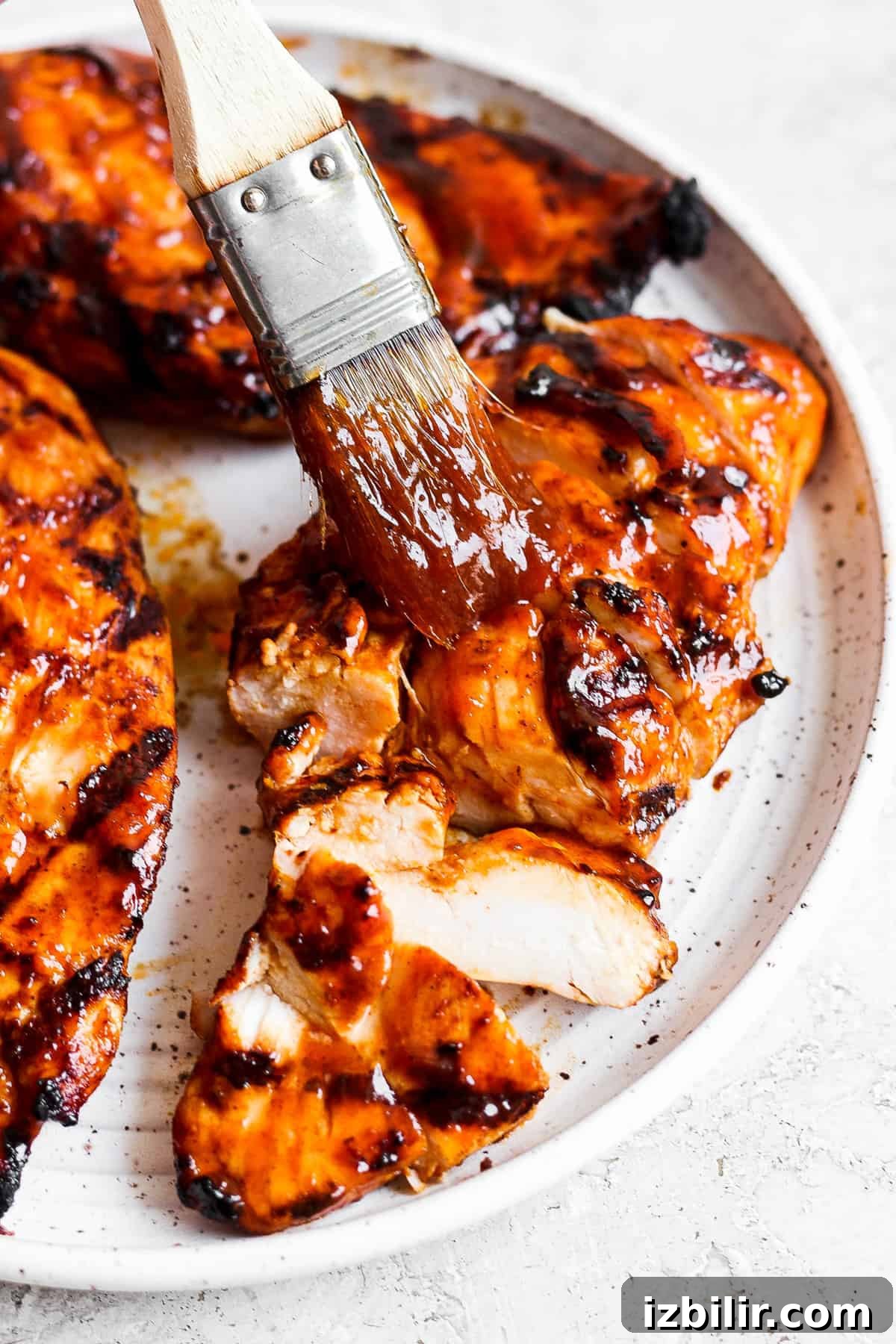 bbq chicken on a plate with a brush.