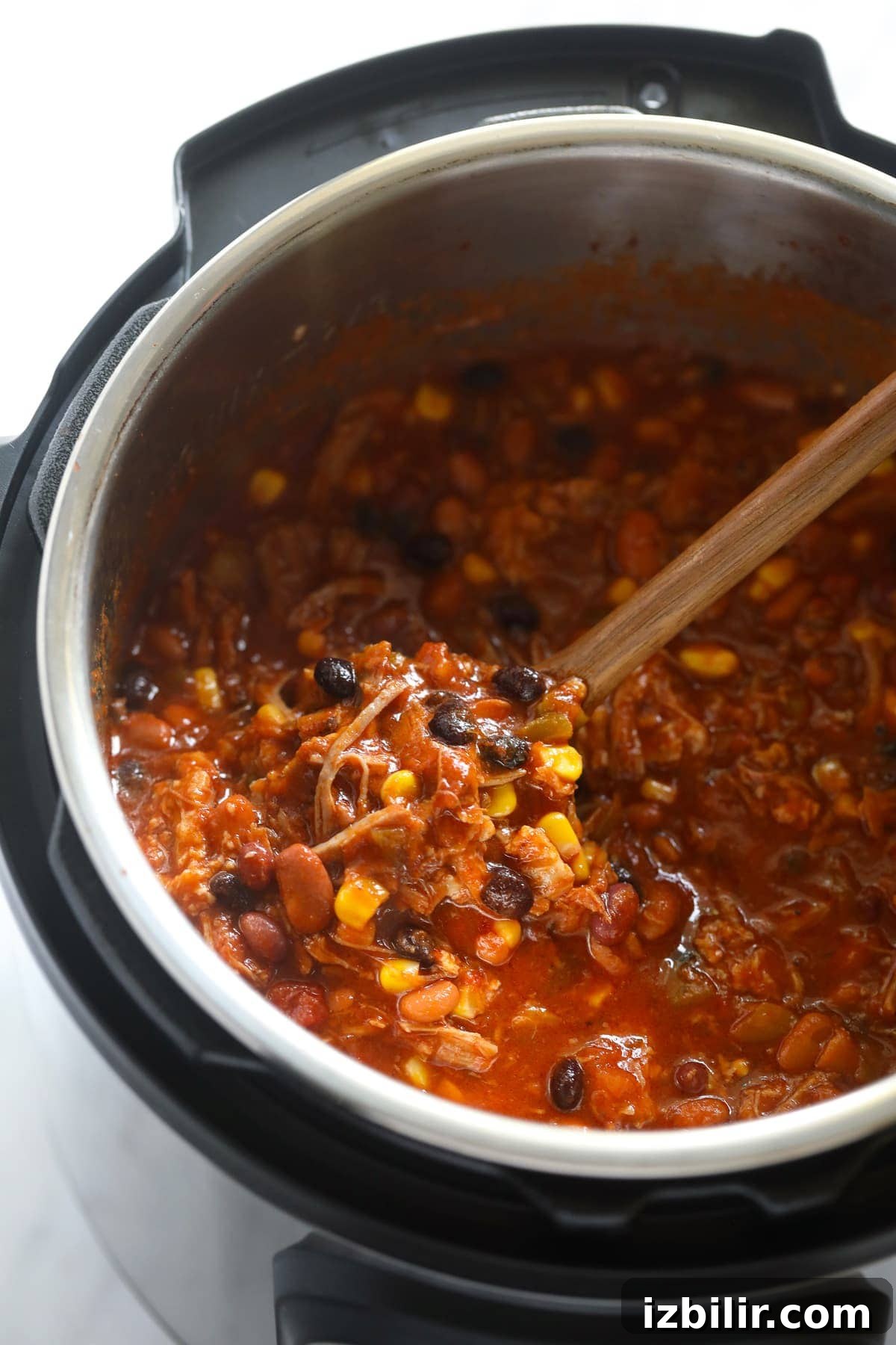 pulled pork chili in instant pot with spoon.