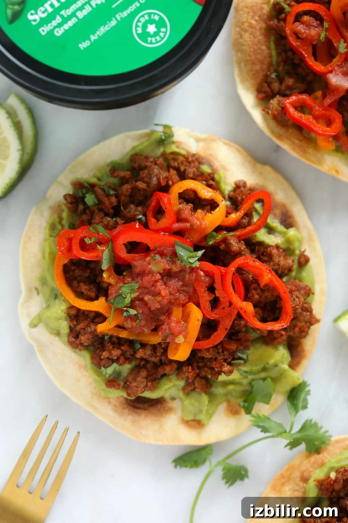 Assembled vegetarian tostada tostada with guacamole, plant based ground, peppers, and salsa