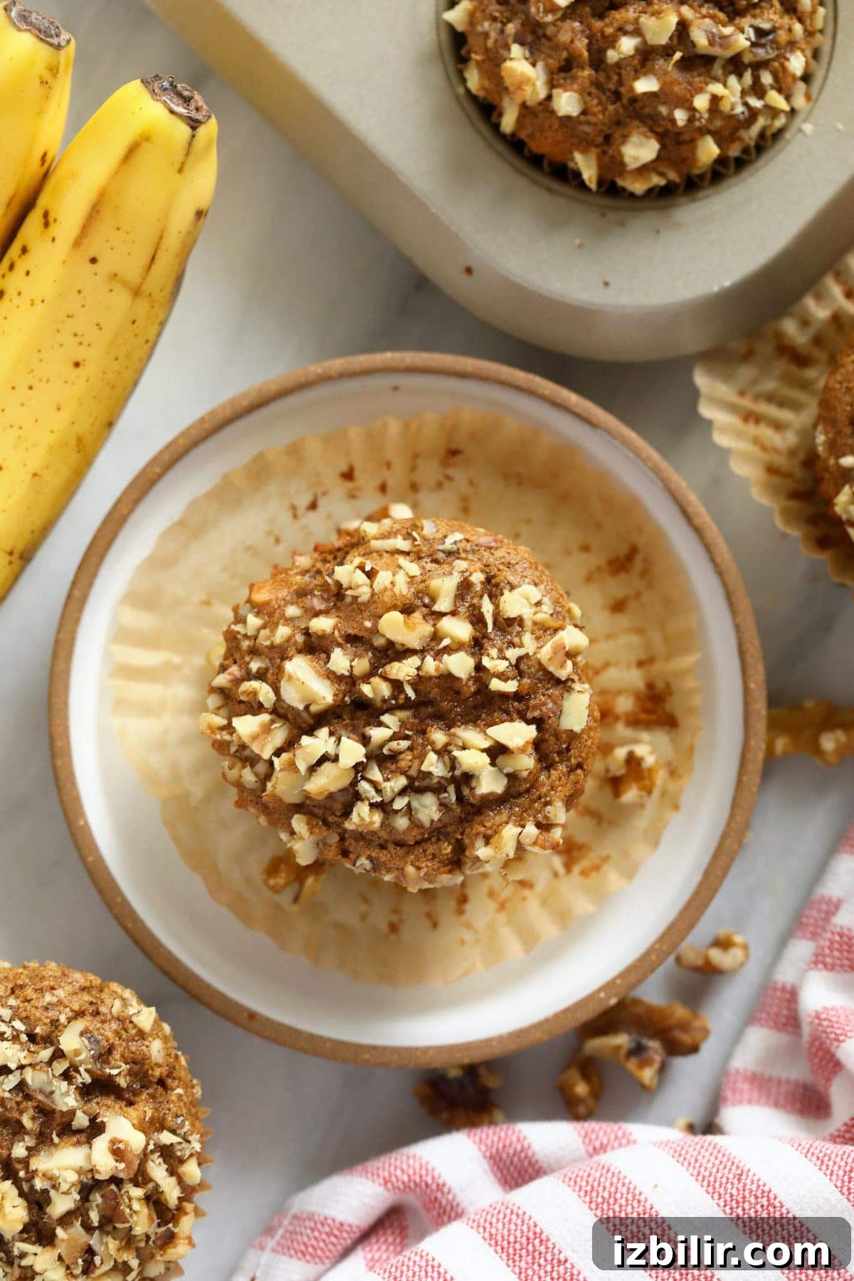 Banana nut muffins on a plate and in a muffin pan.