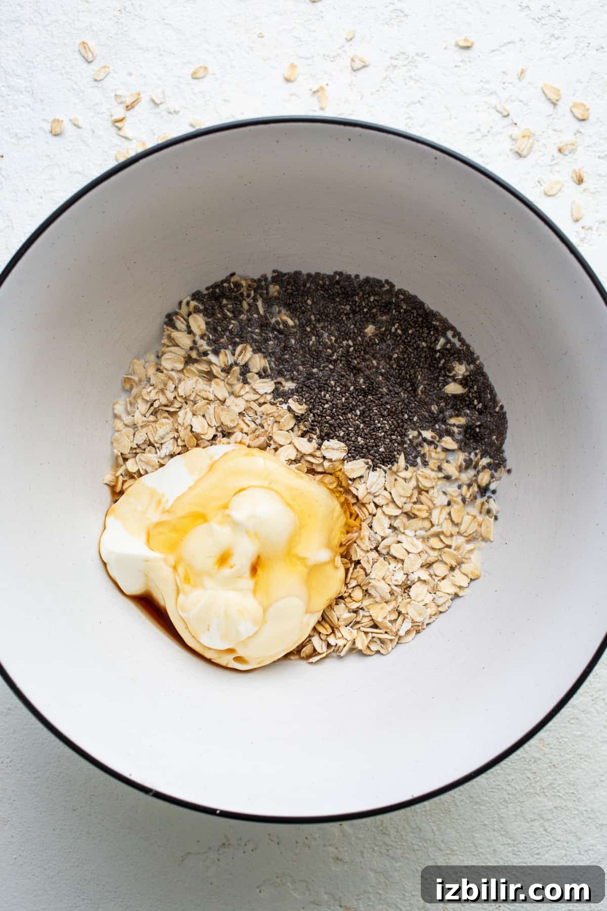 A bowl of oatmeal, oats and a dollop of whipped cream.