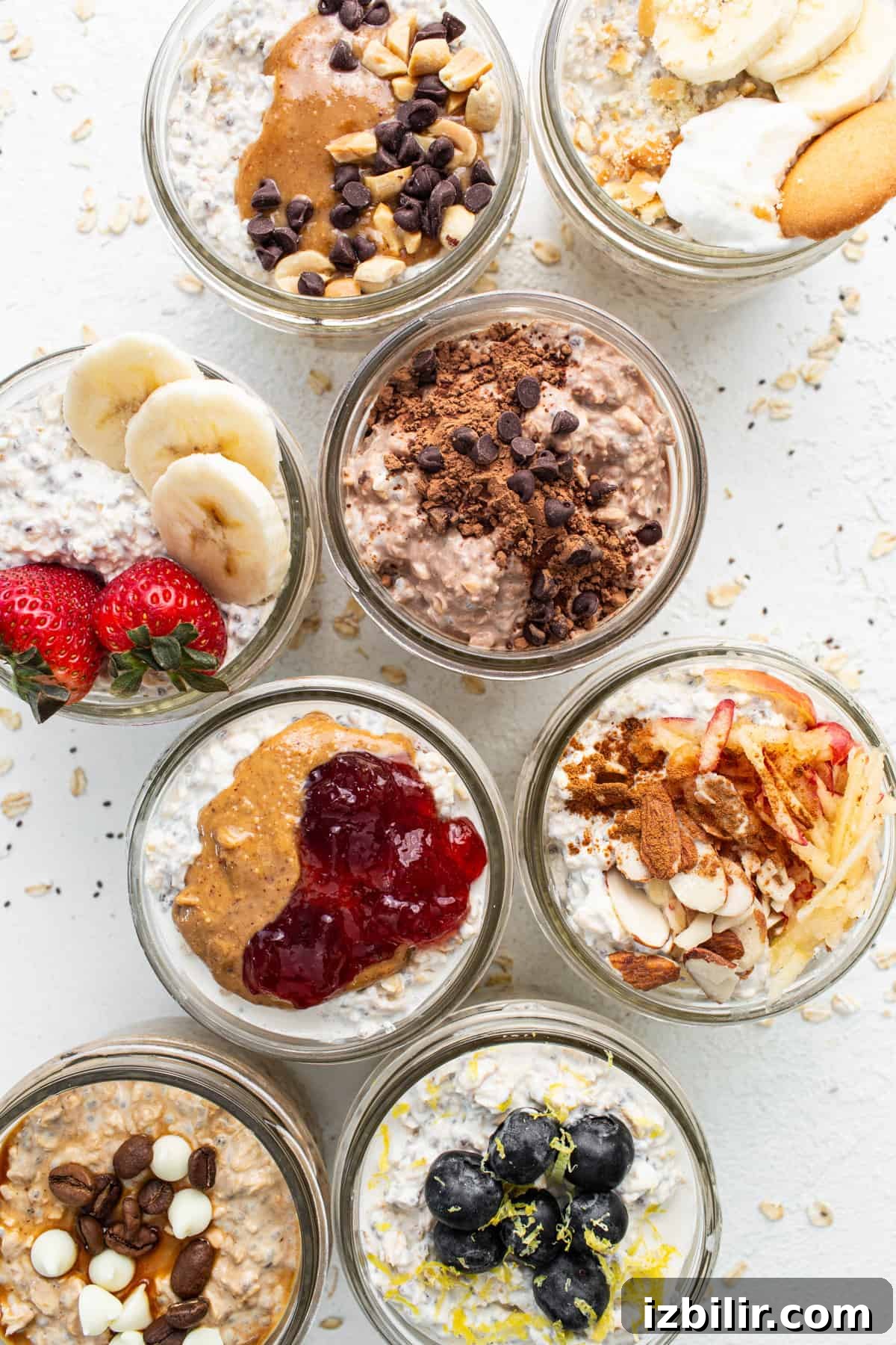 A group of jars filled with oatmeal, fruit, and nuts.