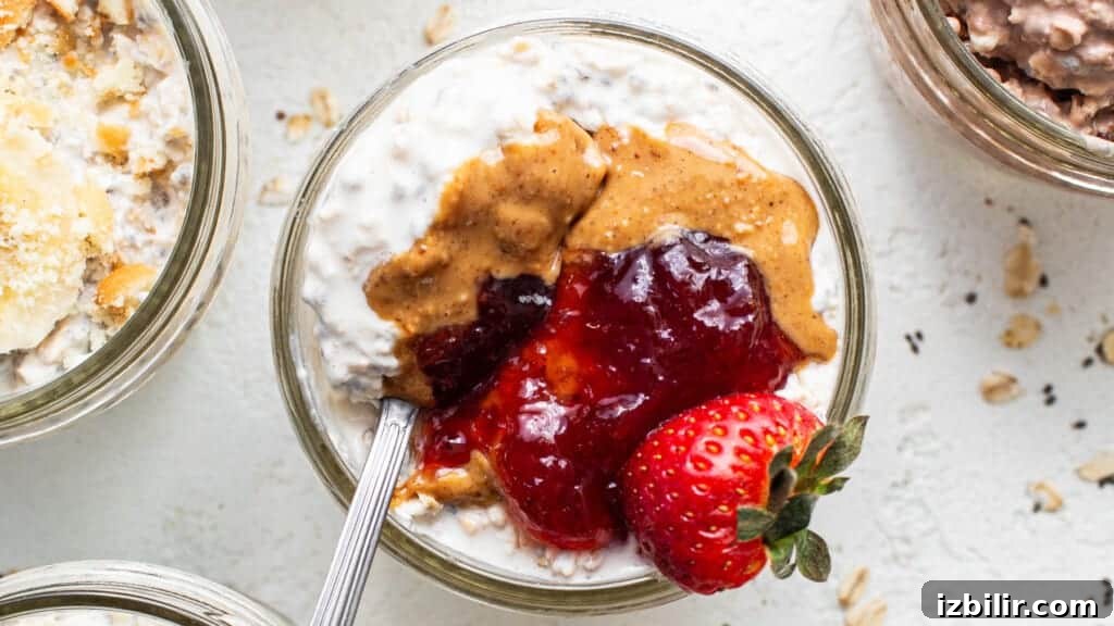 A bowl of oatmeal with peanut butter, jelly and strawberries.