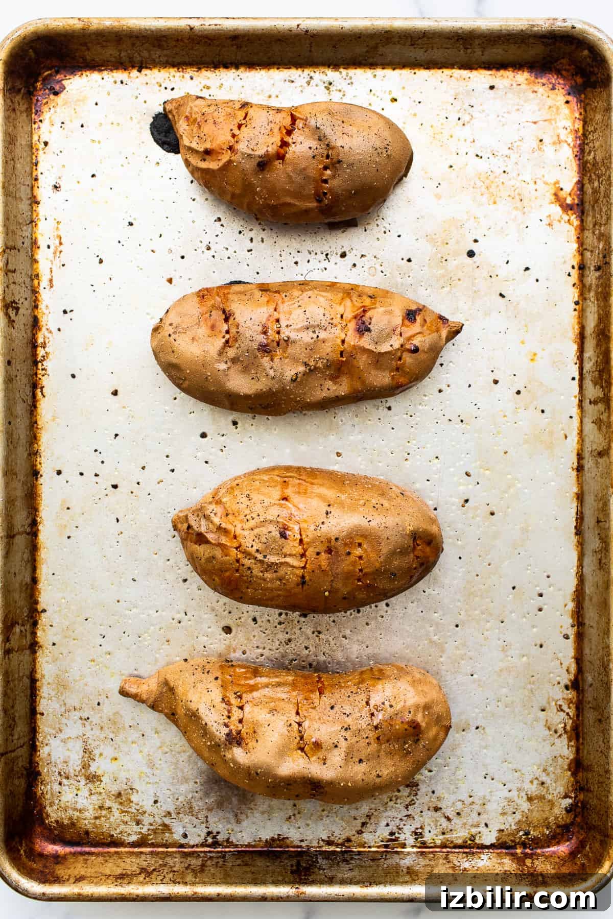 Baked sweet potatoes on a baking sheet. Baked sweet potatoes on a baking sheet.