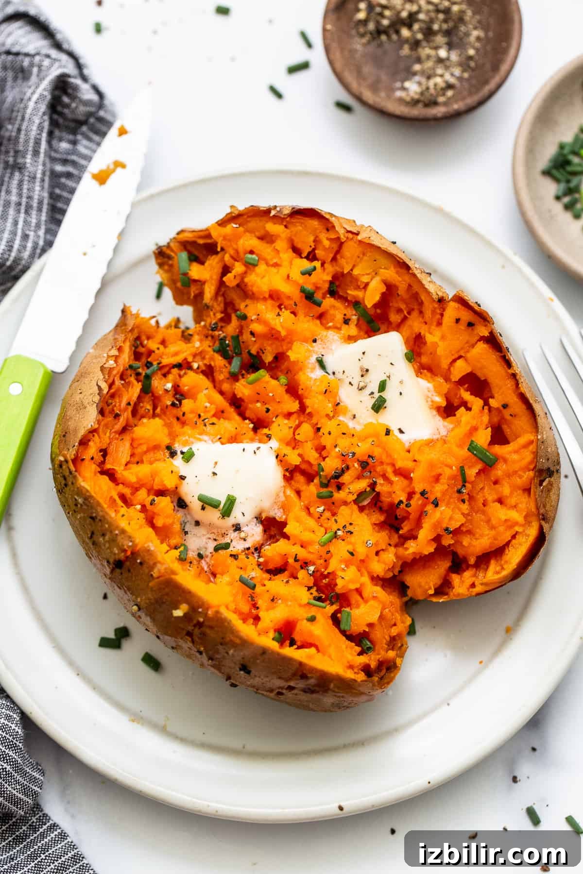 Baked sweet potatoes on a plate. Baked sweet potato on a plate topped with butter.