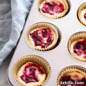 Mini Cranberry Swirl Greek Yogurt Cheesecake Bites Recipe 8 cranberry cheesecakes in a muffin tin.
