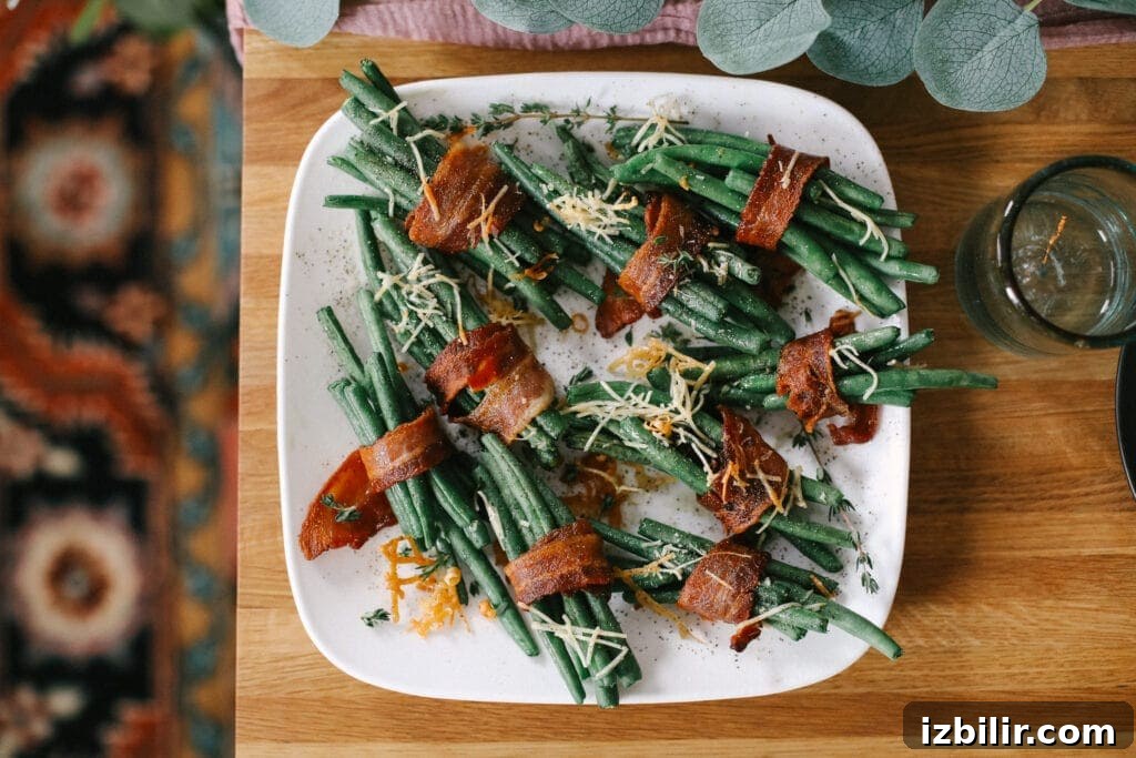 This Thanksgiving appetizer idea is finger-lickin' good. Little bundles of green beans wrapped in bacon and baked to perfection. Yes, please! green beans on plate on table