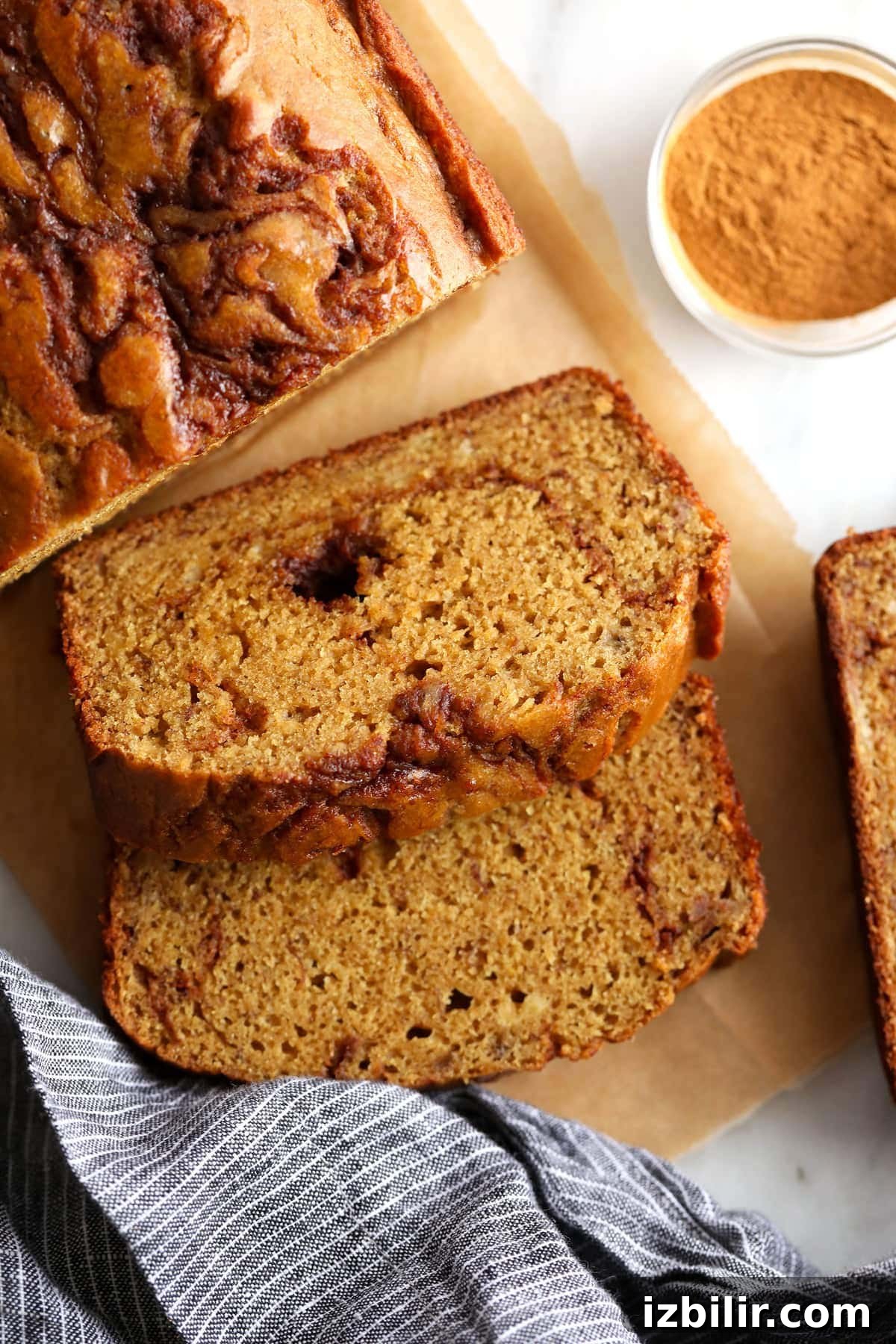 A piece of cinnamon swirl banana bread on cutting board.