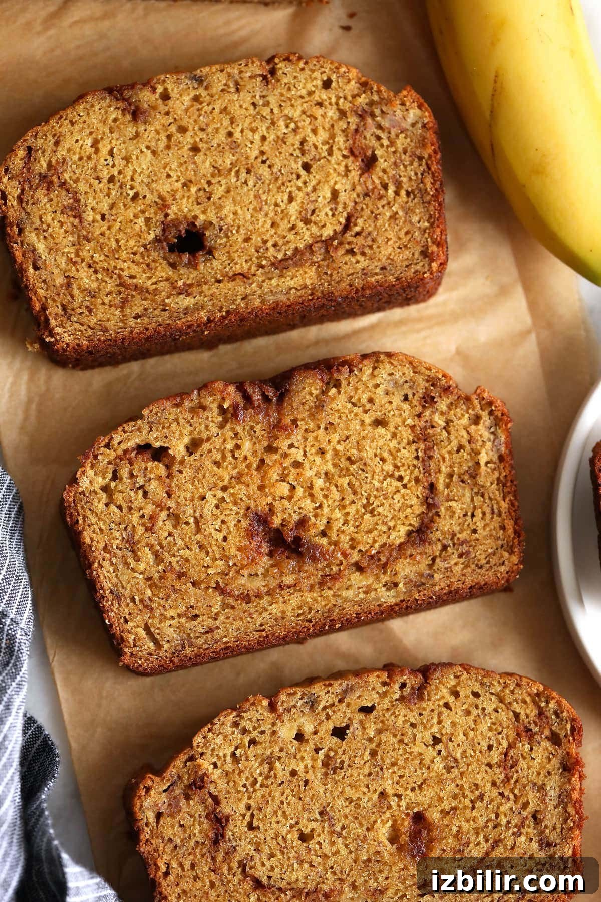 Cinnamon swirl banana bread slices on parchment paper.