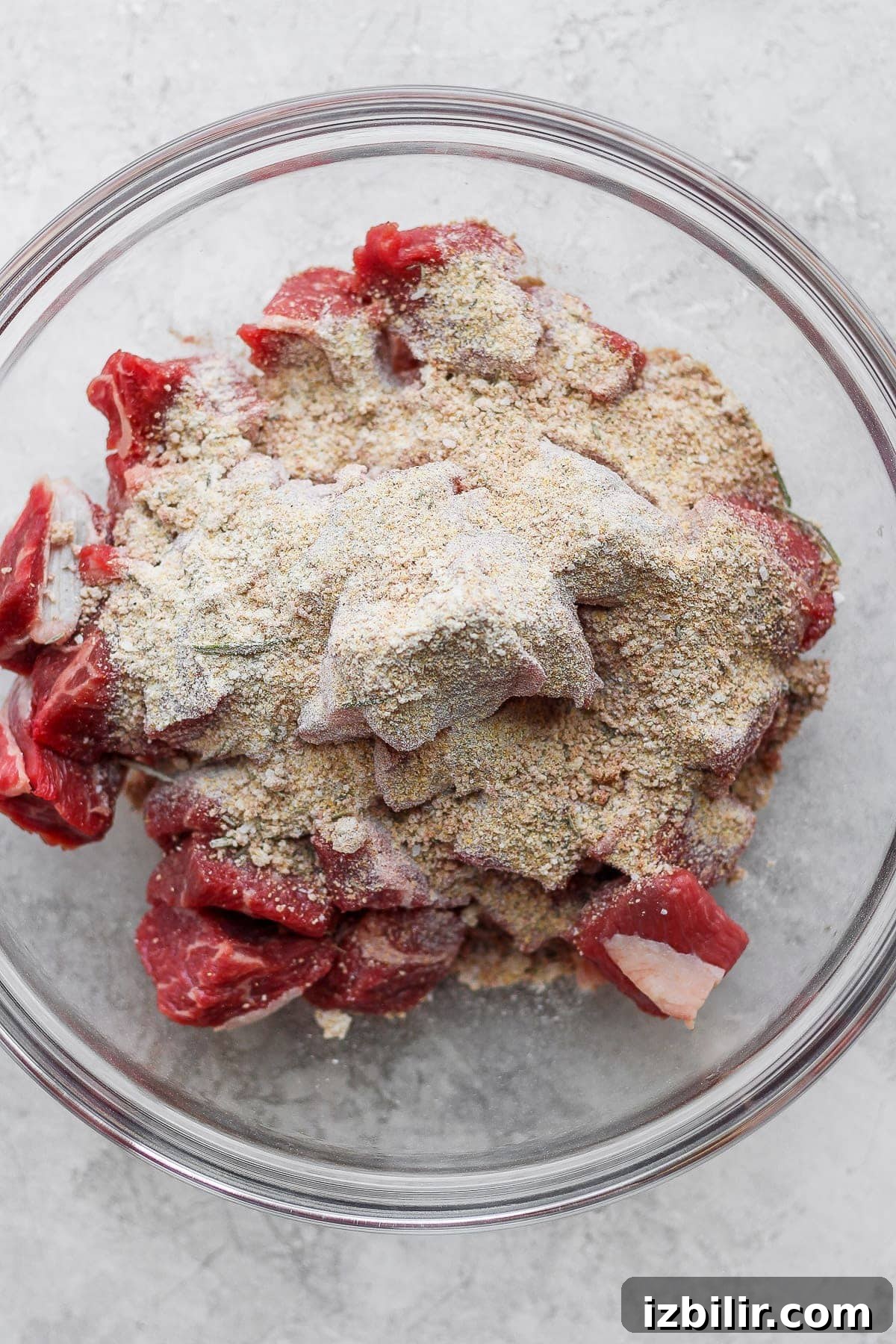 Beef chunks and beef stew seasoning in a bowl.