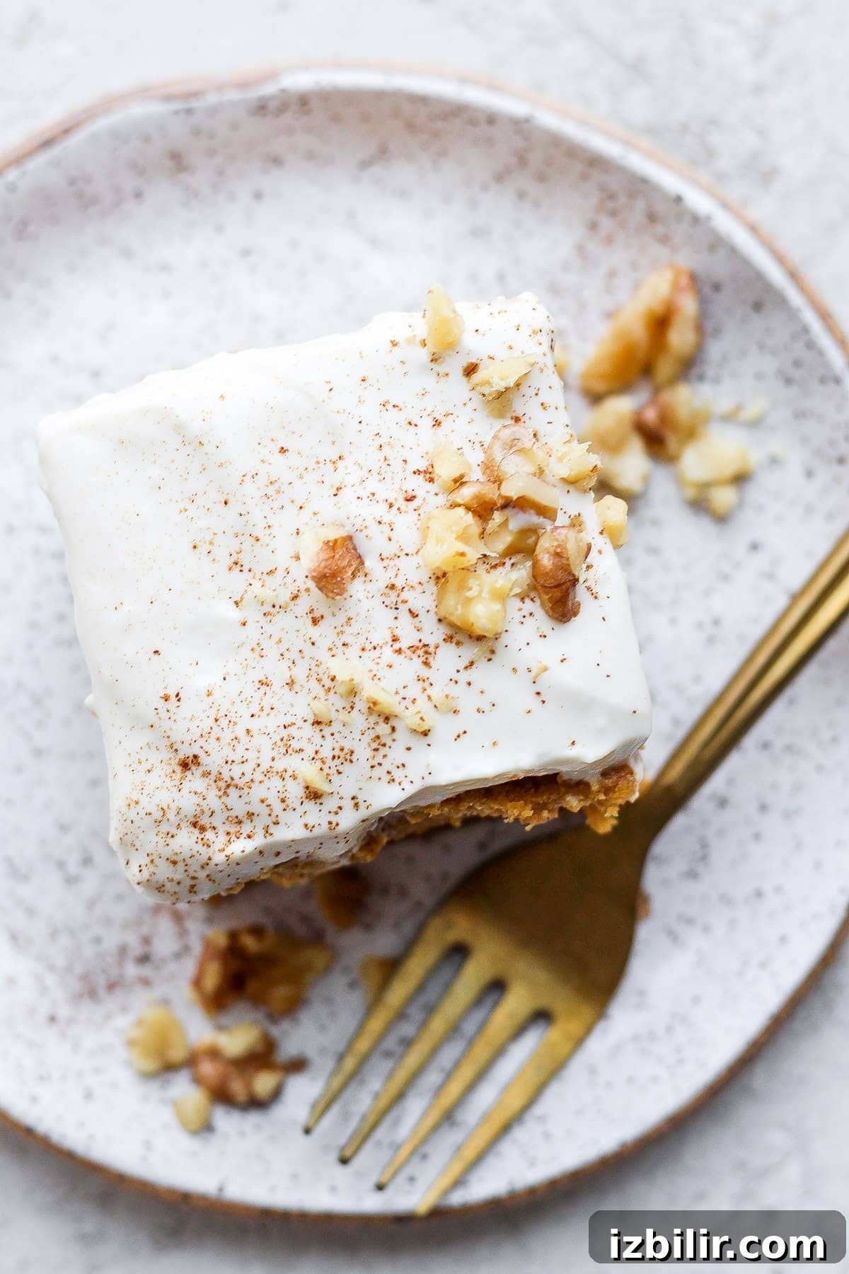 This Greek yogurt cream cheese frosting is the most delicious healthy cream cheese frosting we've ever had! Pumpkin cake on plate.
