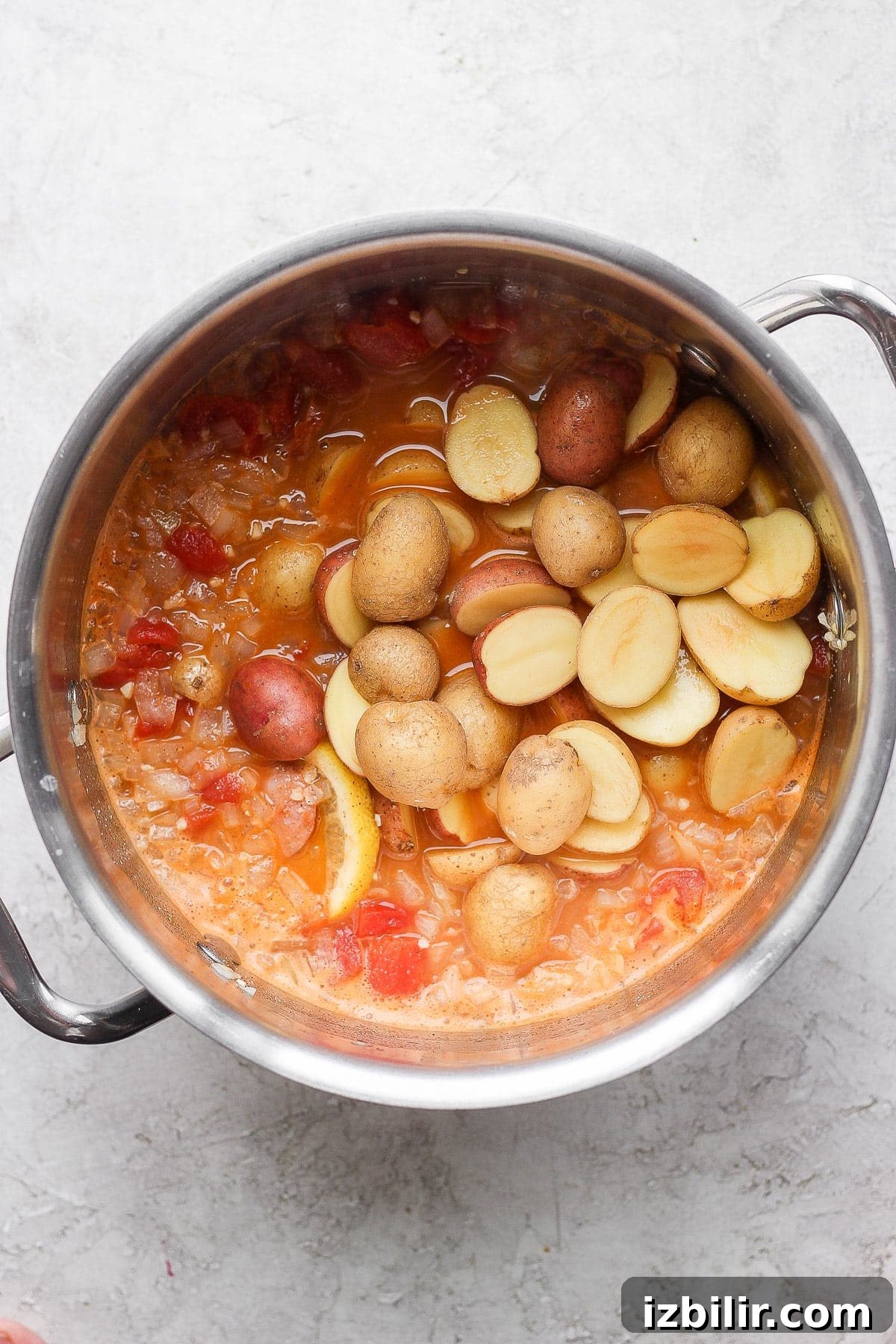 potatoes being added to a seafood boil broth