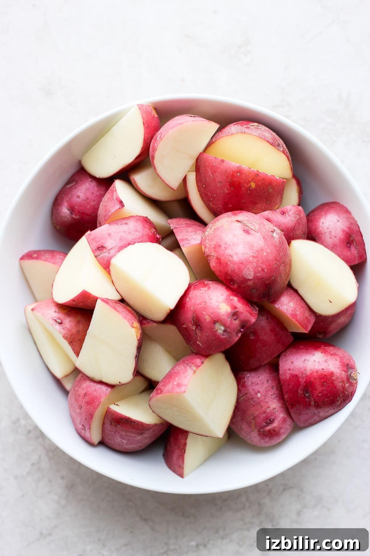 These Ranch Roasted Potatoes are flavor-packed and deliciously crispy! Whip up a batch for the most flavorful side dish. sliced red potatoes ready to be tossed in ranch and roasted