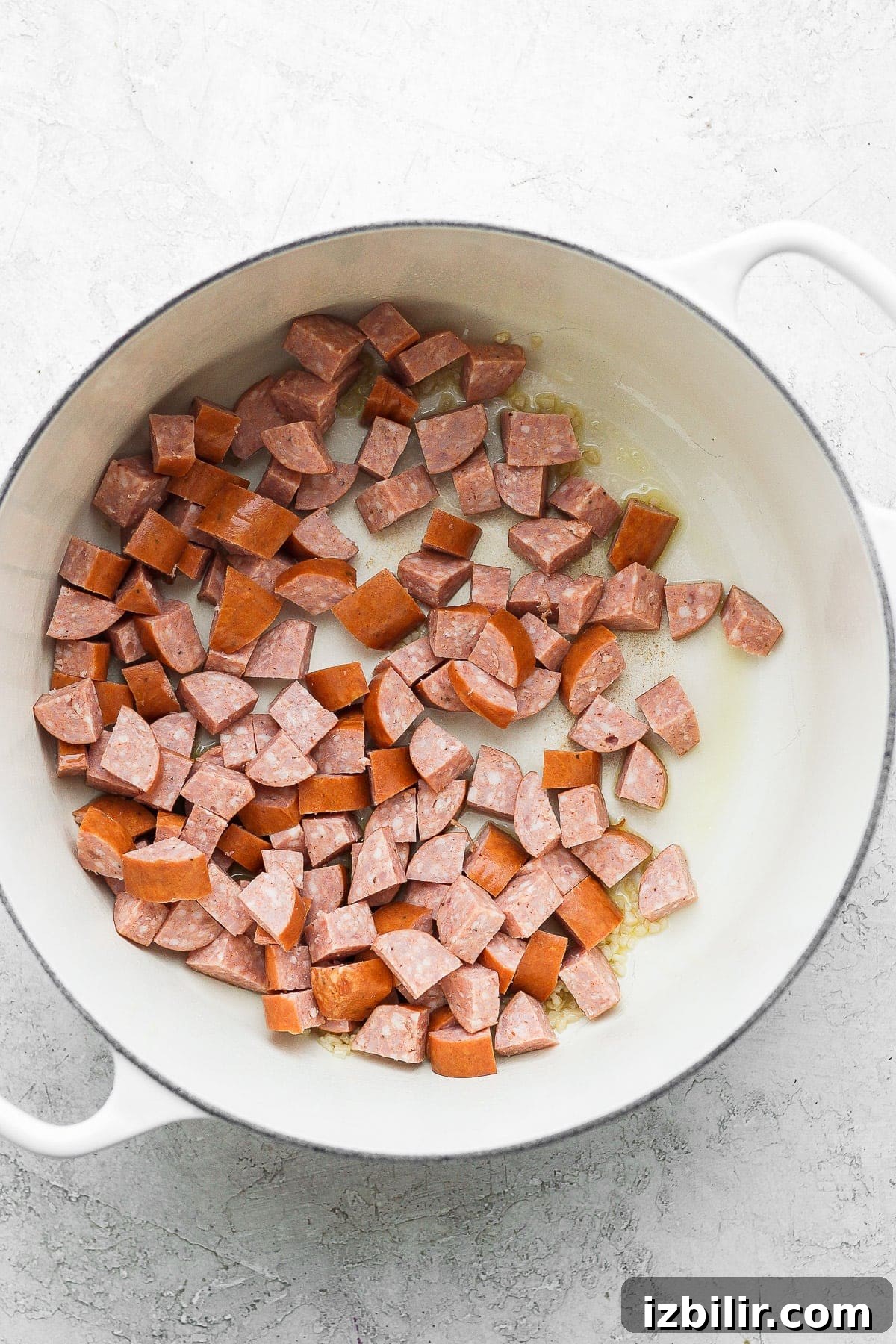 andouille sausage in a dutch oven ready to be sautéed