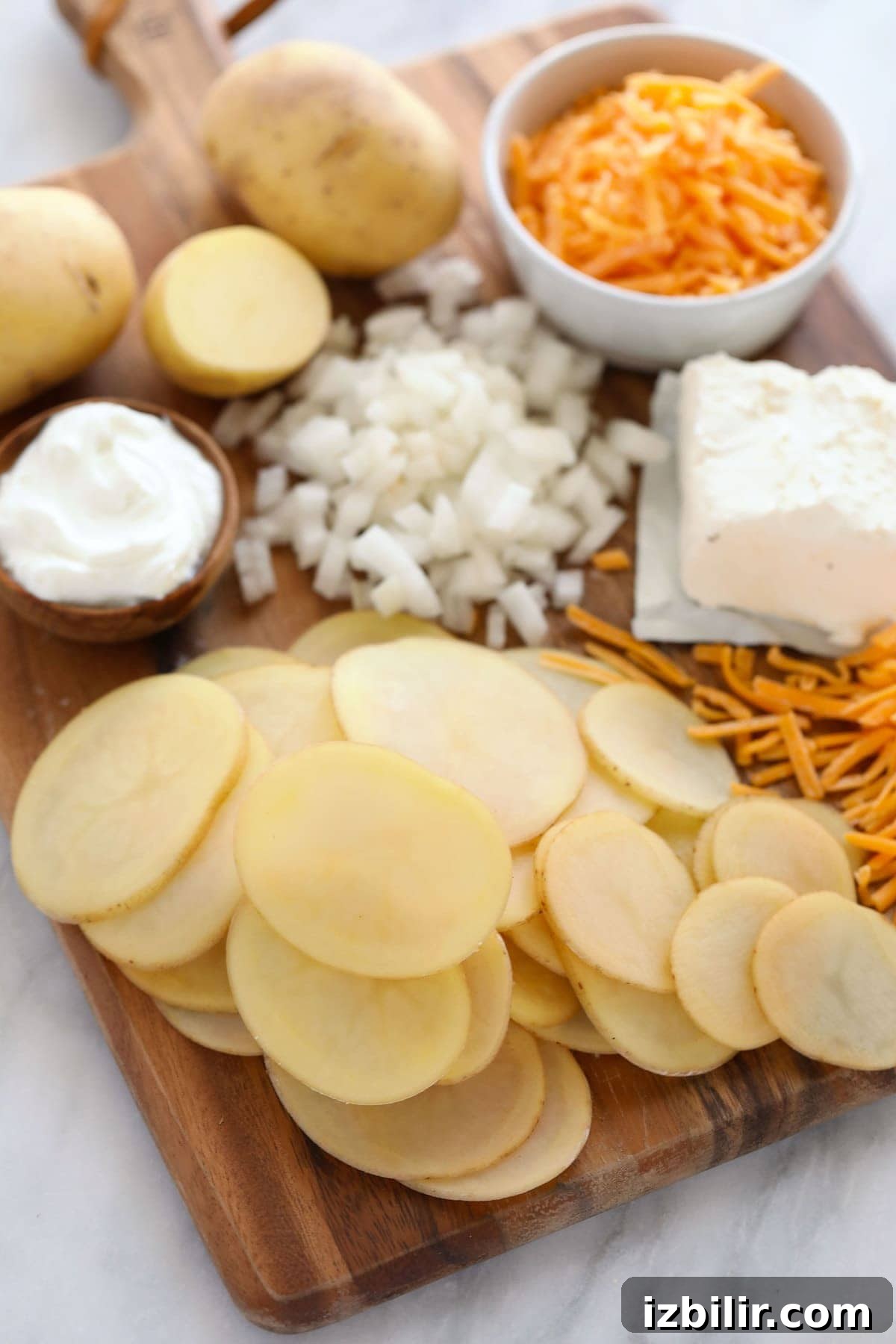 all the ingredients for scalloped potatoes on a cutting board.
