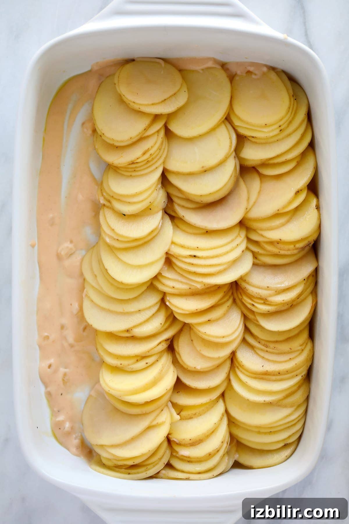 A casserole dish with potatoes and cheese sauce. 