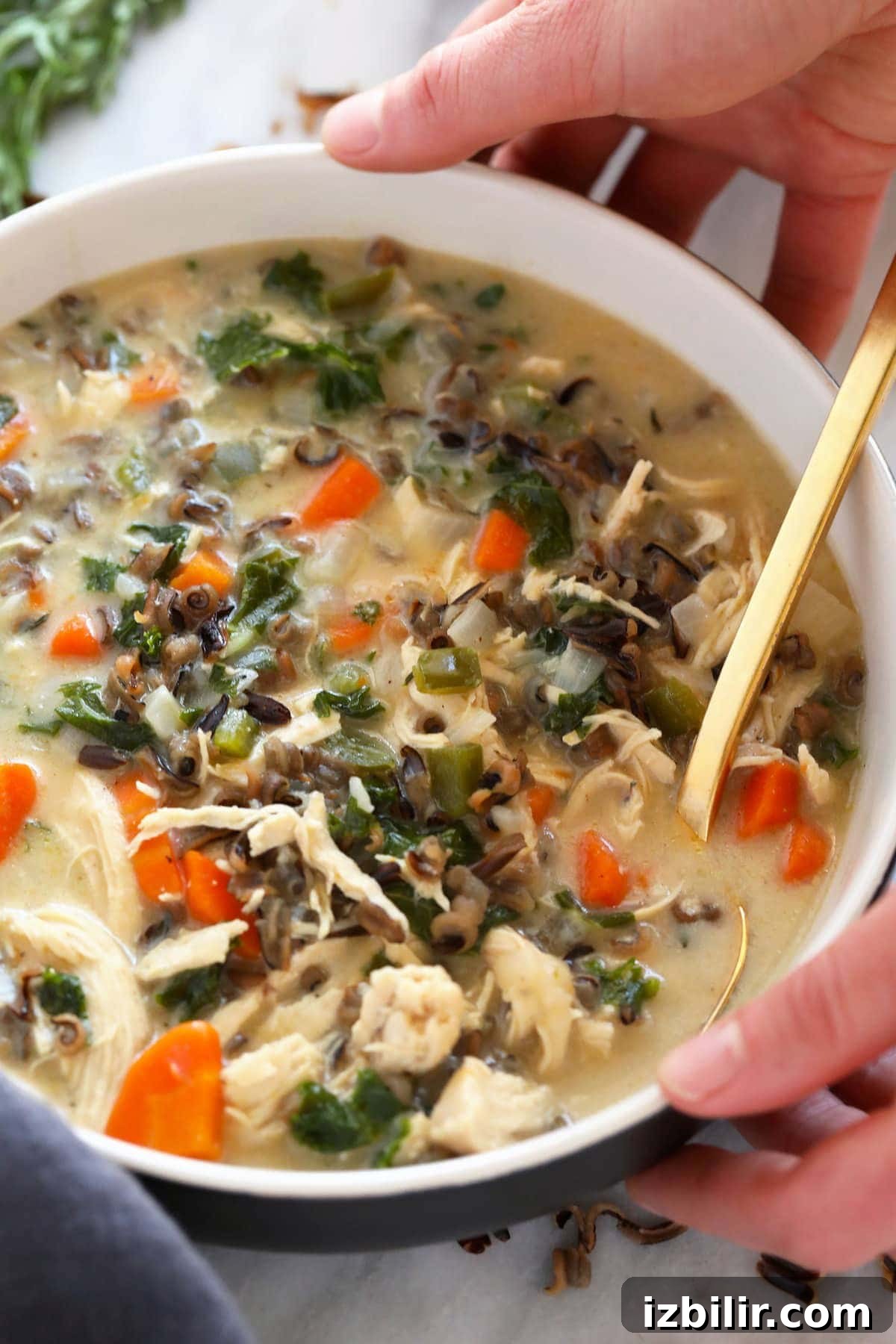 This cozy stovetop Chicken Wild Rice Soup is packed with healthy veggies and made creamy with a delicious roux. Make a large batch and enjoy it throughout the week! Chicken wild rice soup in a bowl.