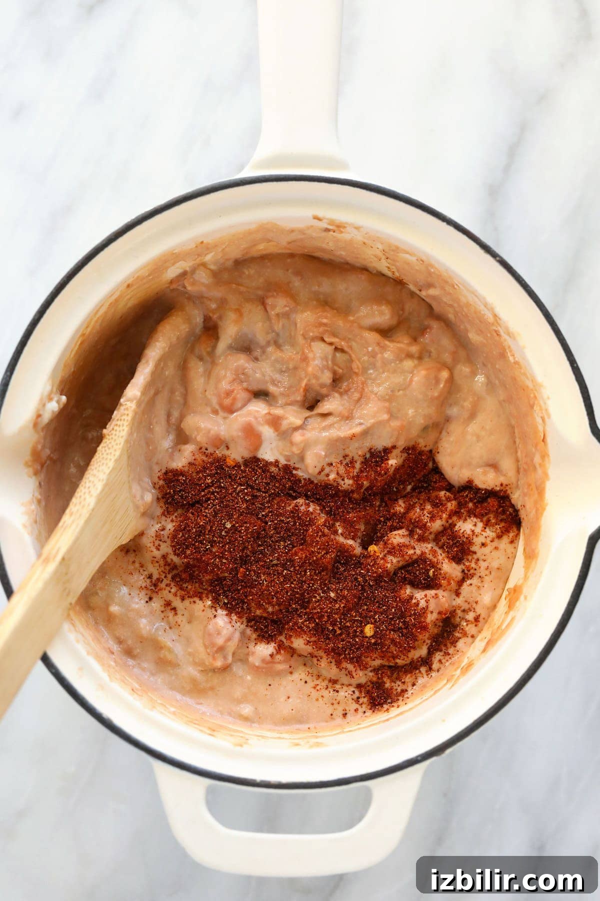 bean dip ingredients being mixed together in a skillet