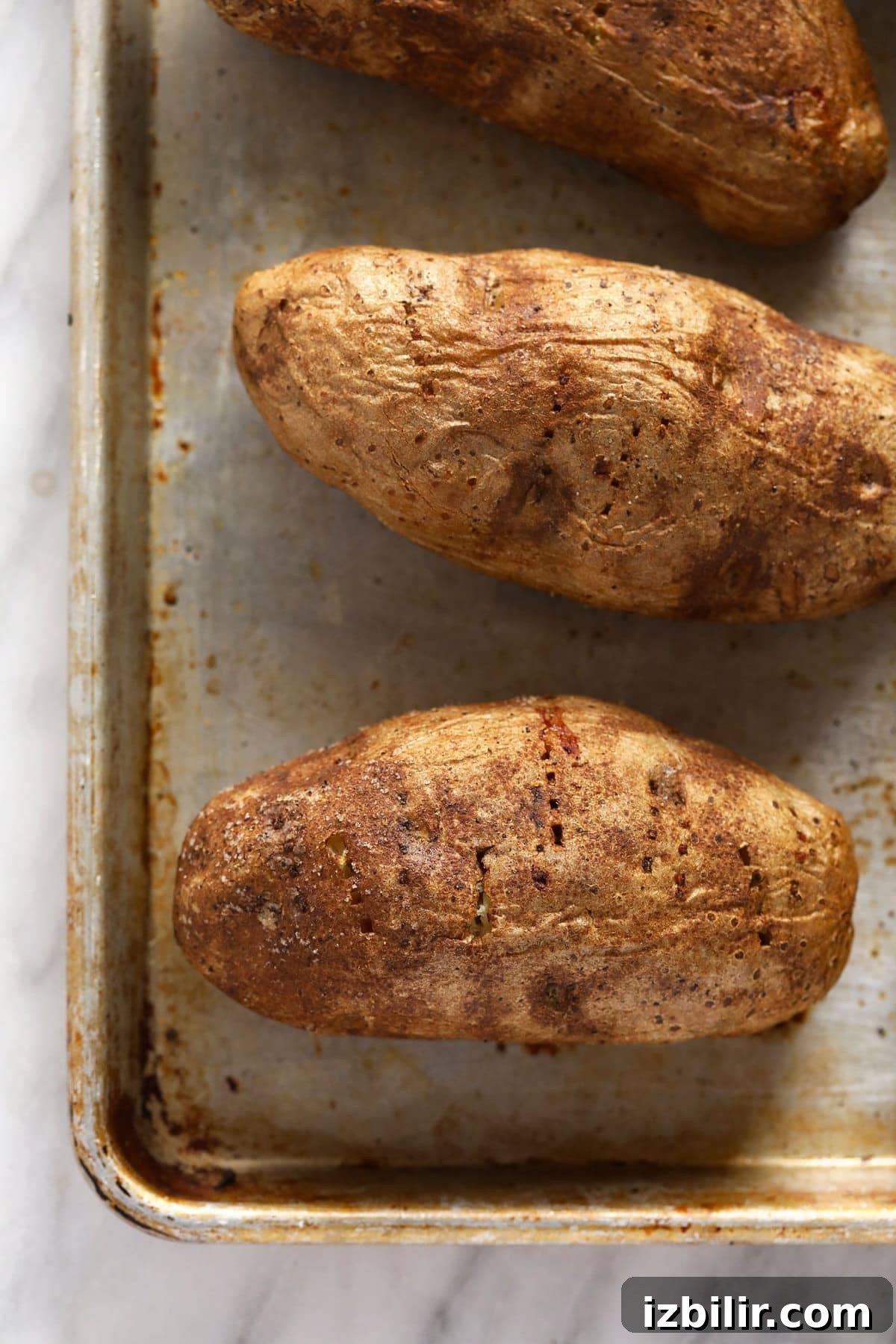 Tray of golden roasted baked potatoes.