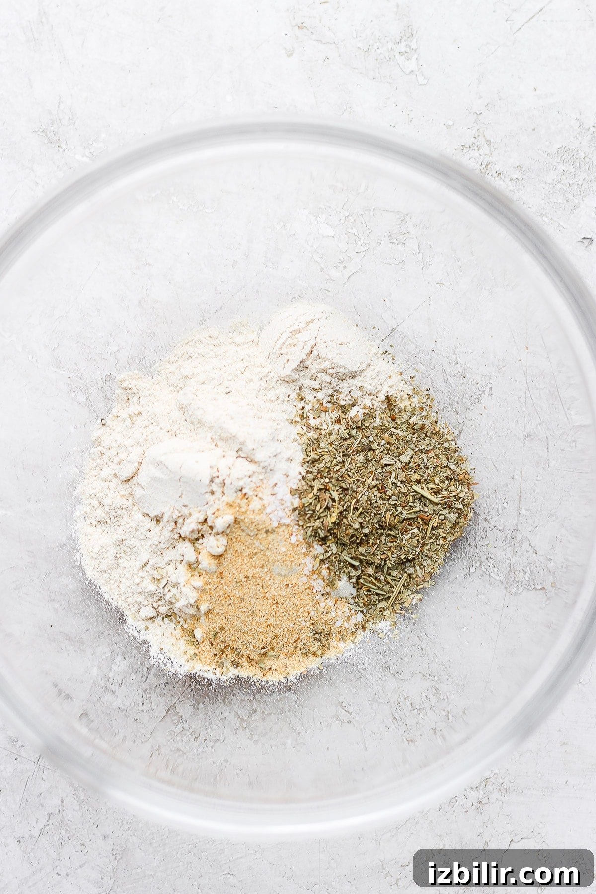 Flour and spices in a clear bowl.