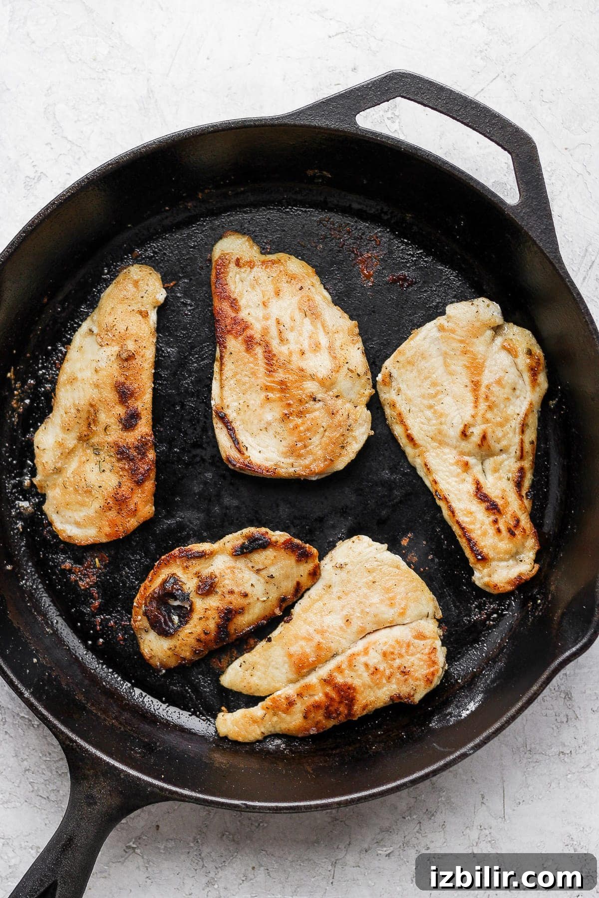 Browning chicken in a cast iron pan.