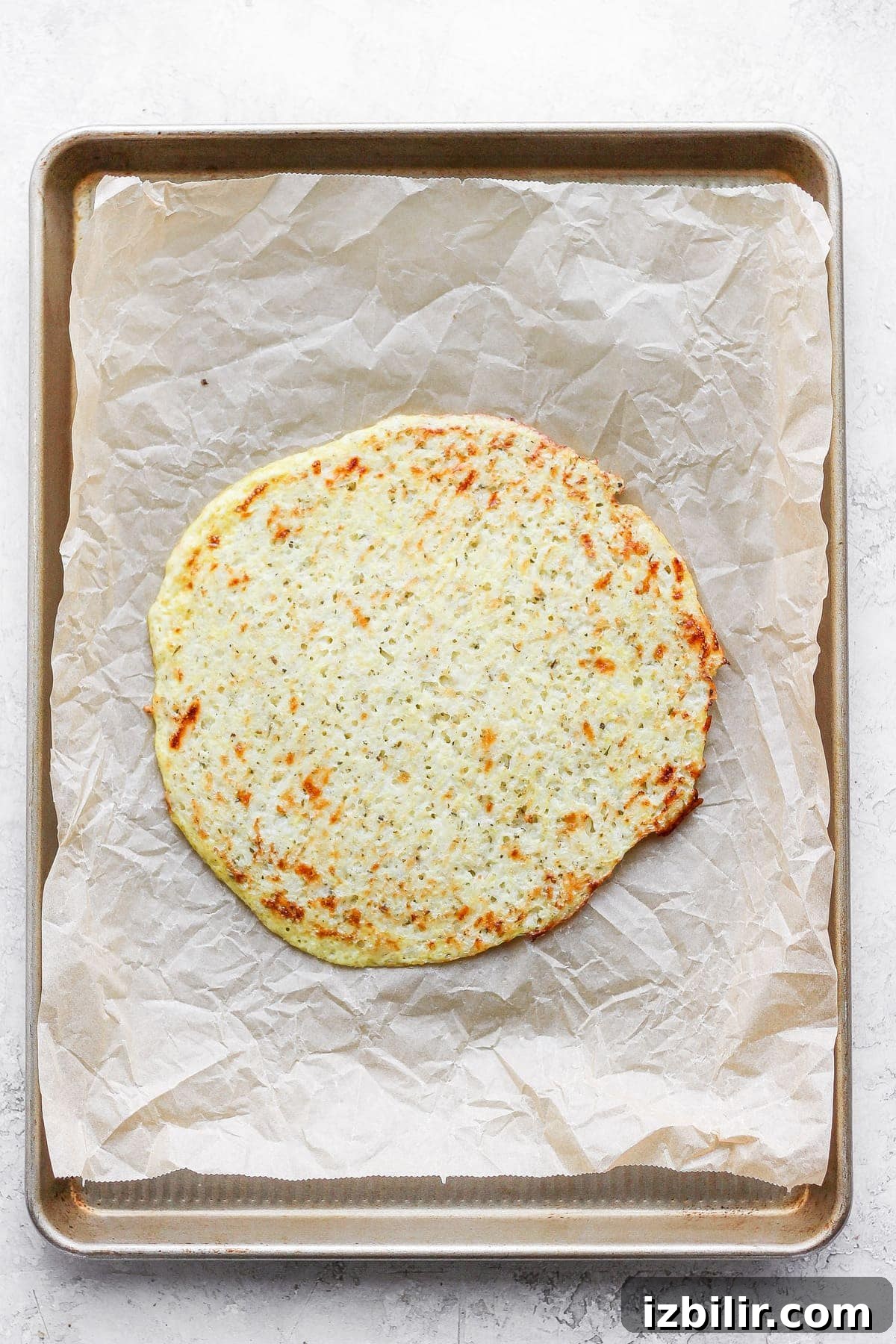 Gluten-Free Cauliflower Pizza Crust Recipe 9 Golden cauliflower pizza crust on parchment paper.