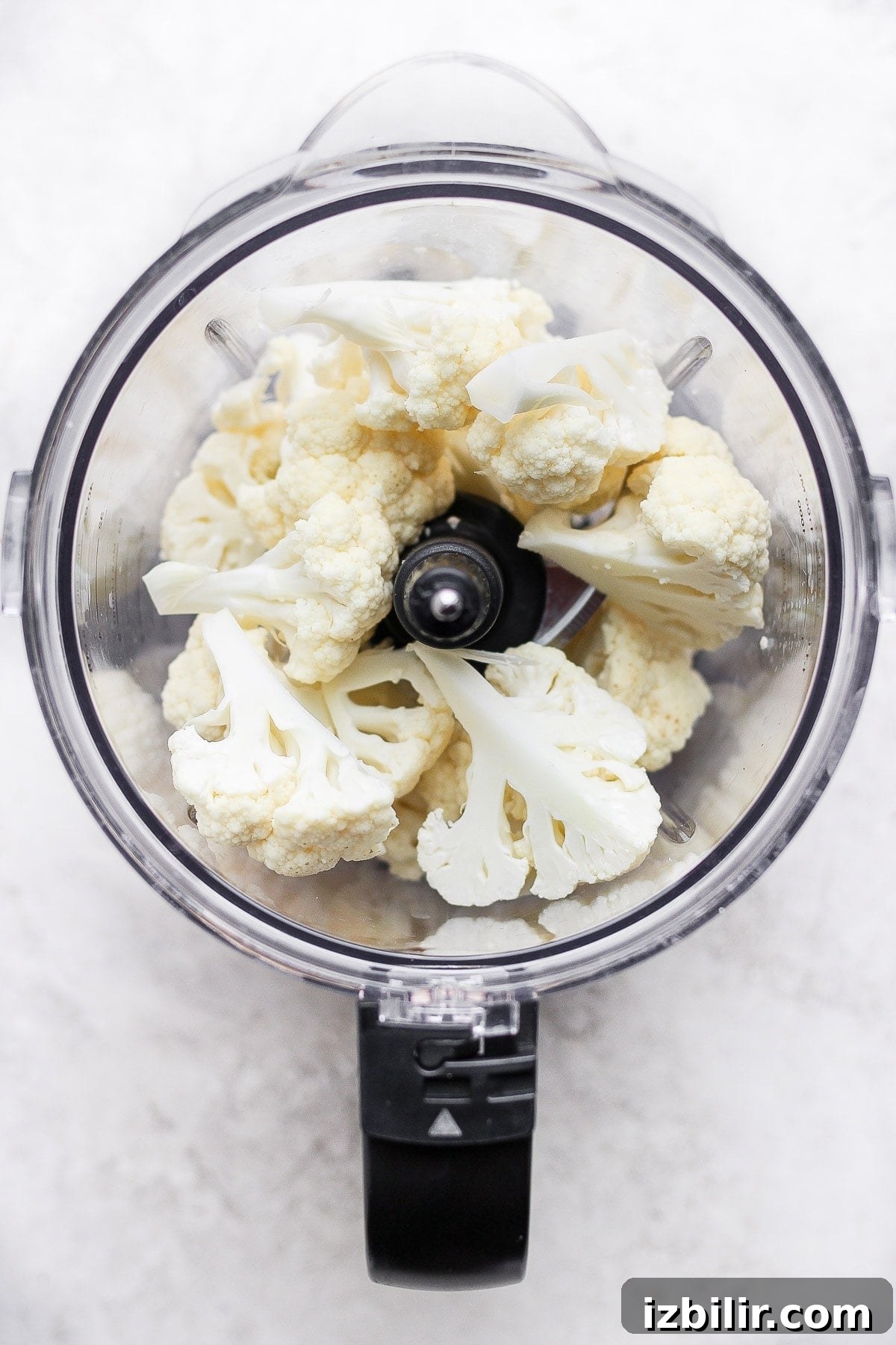 Cauliflower Rice: Quick Low-Carb Recipe 3 Raw florets of cauliflower in a food processor.