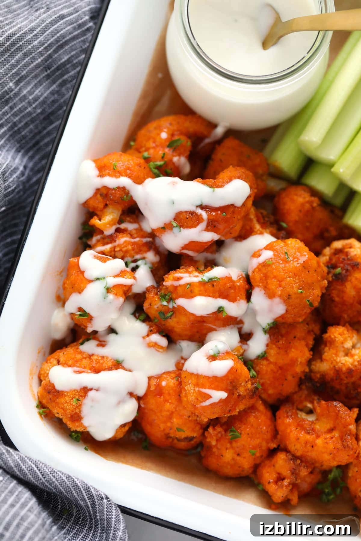 blue cheese sauce drizzled on buffalo cauliflower wings