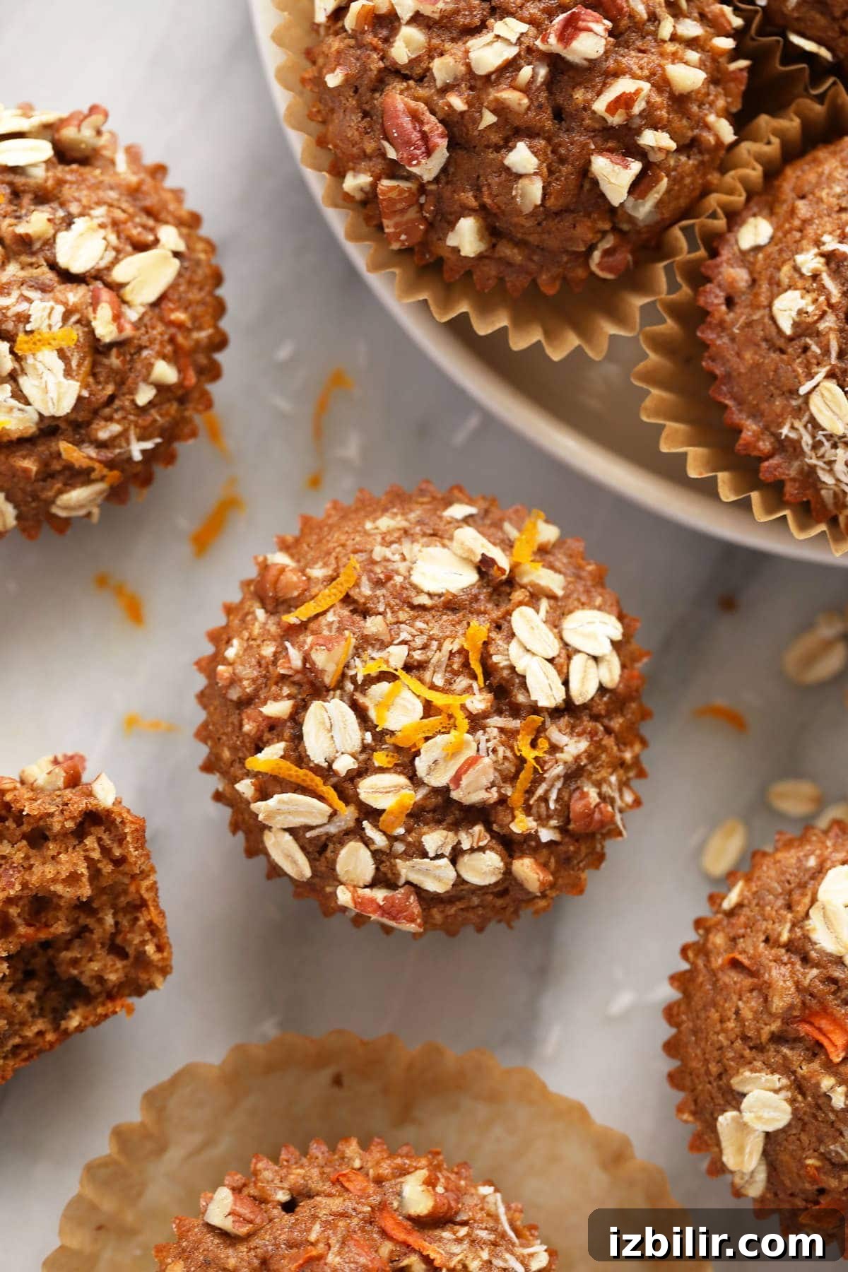 A morning glory muffin with fresh orange zest on top of the muffin.