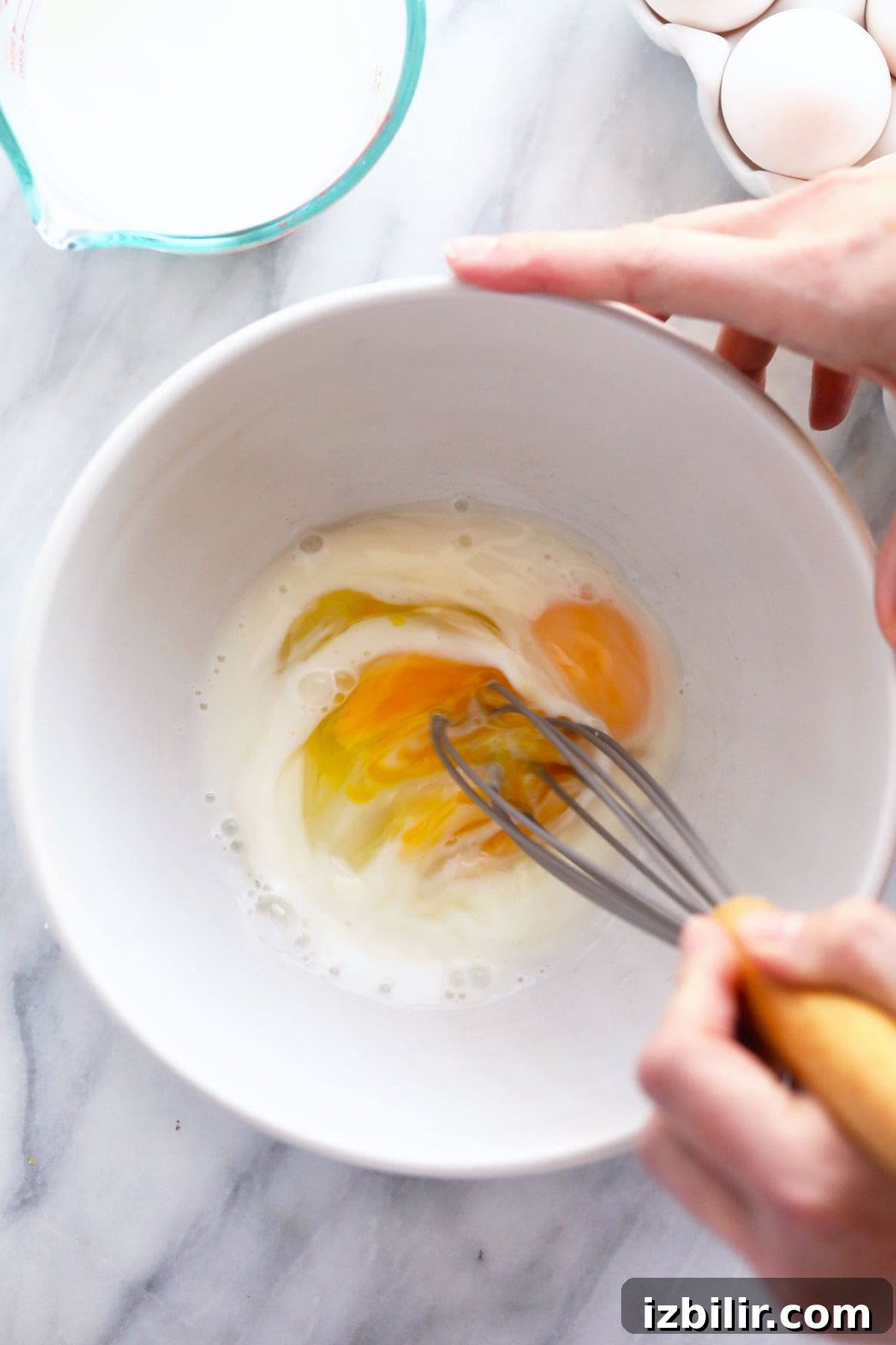Raw eggs and milk ready to be mixed for scrambled eggs raw eggs and milk in a bowl ready to be mixed together for scrambled eggs